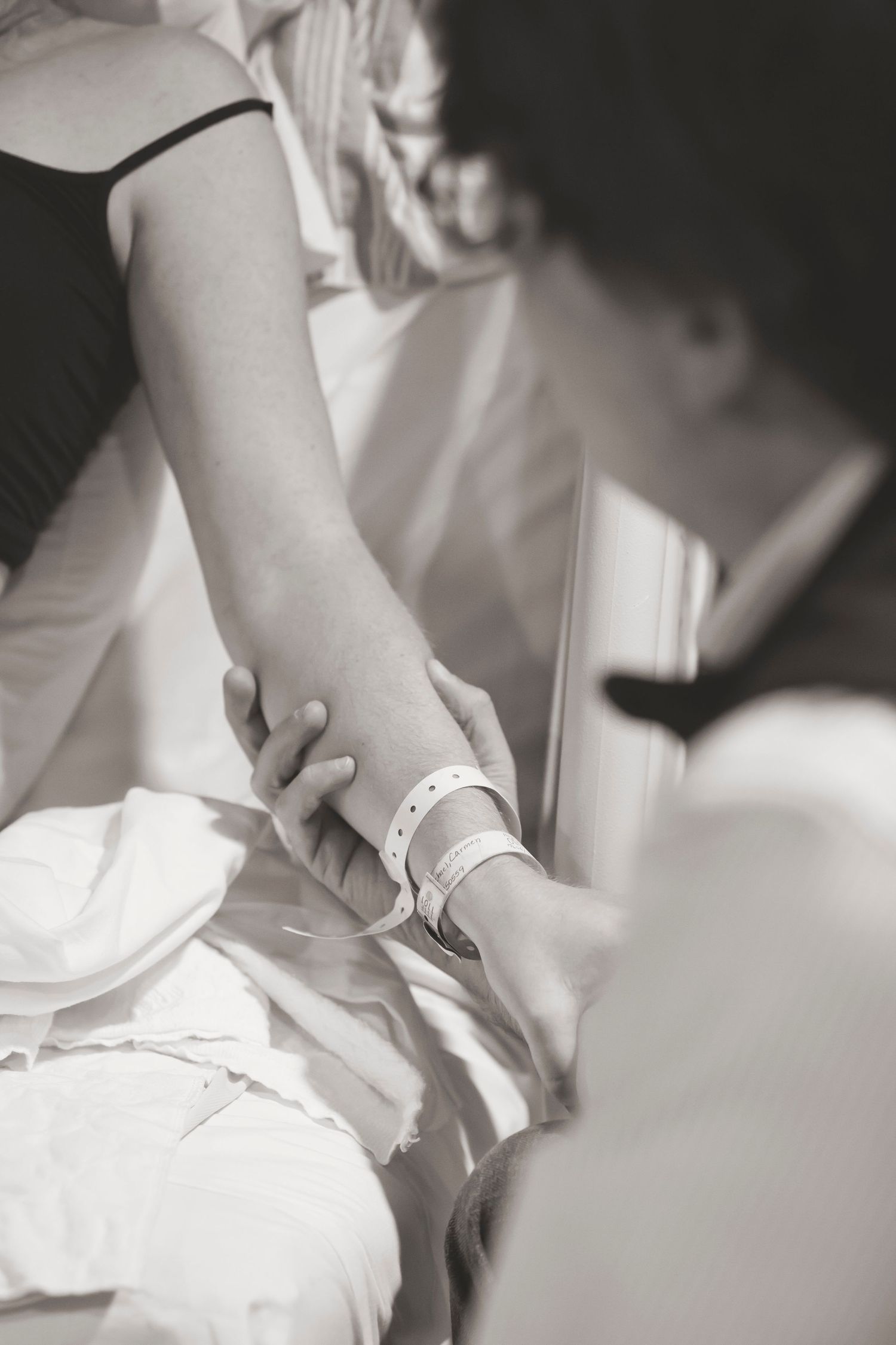 A supportive hand-holding moment between patient and care provider during labor.