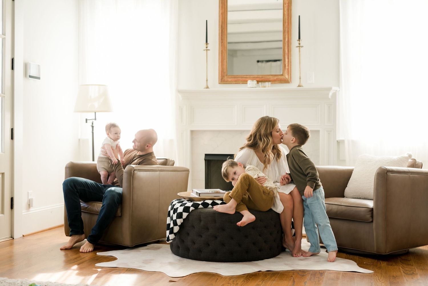 Family relaxing together in a cozy living room with modern furniture and a fireplace.