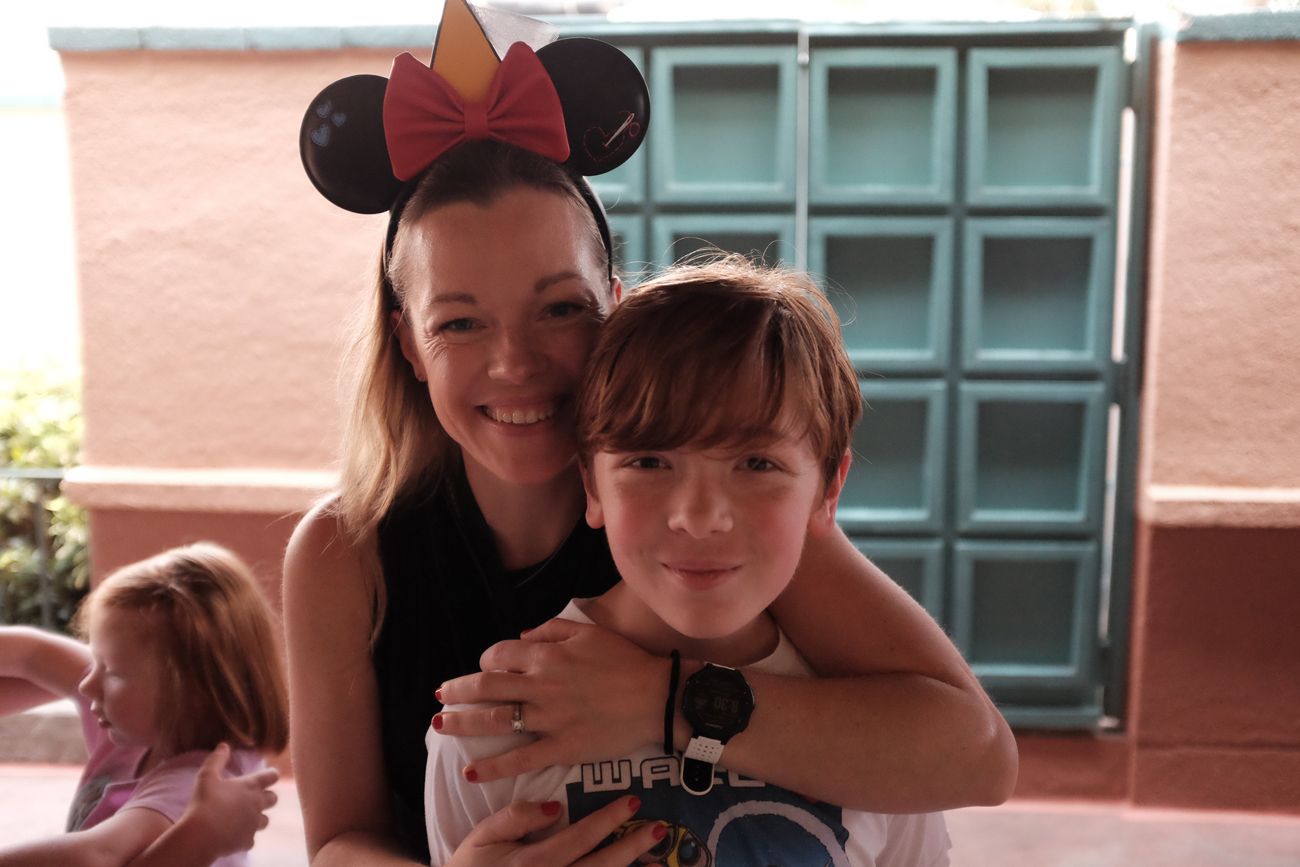 Two people pose together while wearing Mickey Mouse ears at a Disney park.