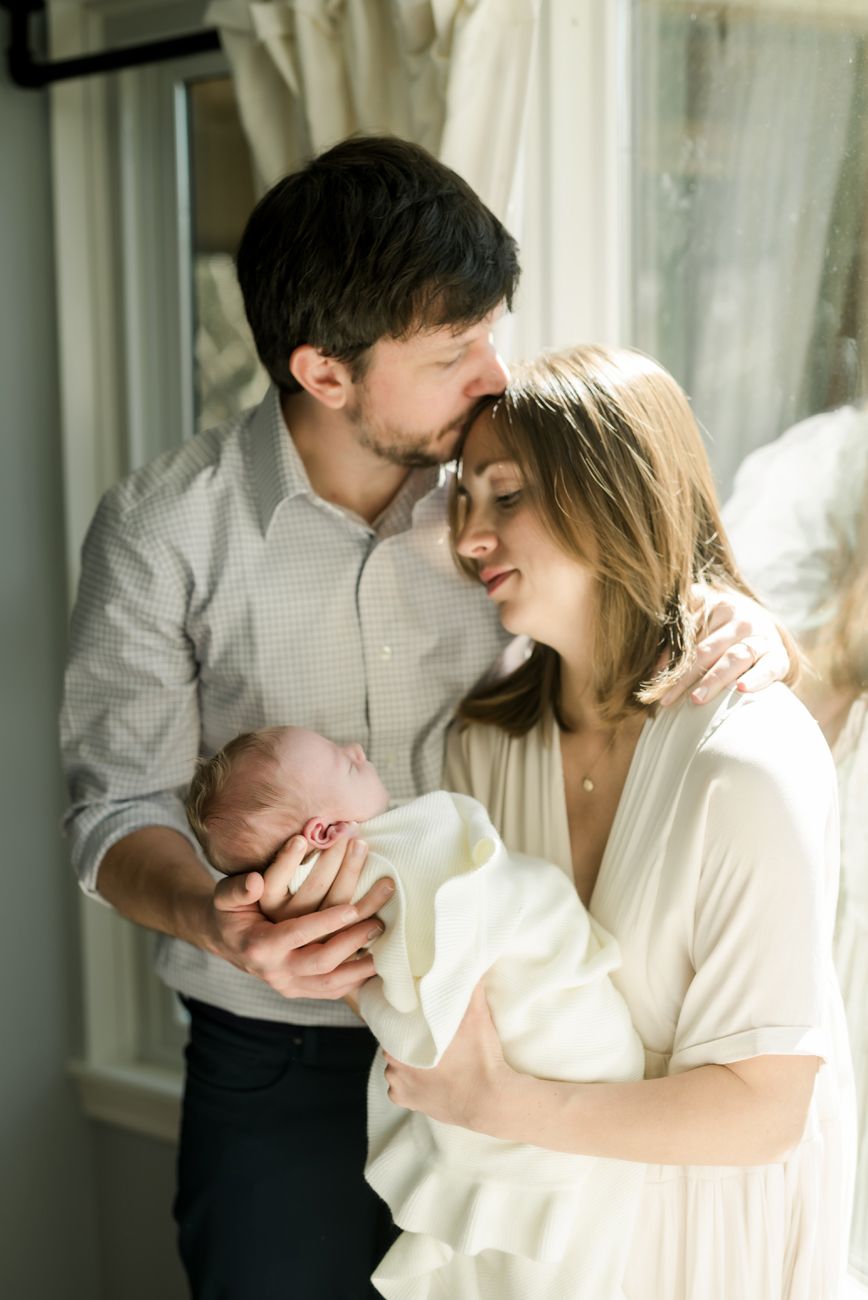 Intimate lifestyle portraits captured in a bright room with soft white curtains and natural light.