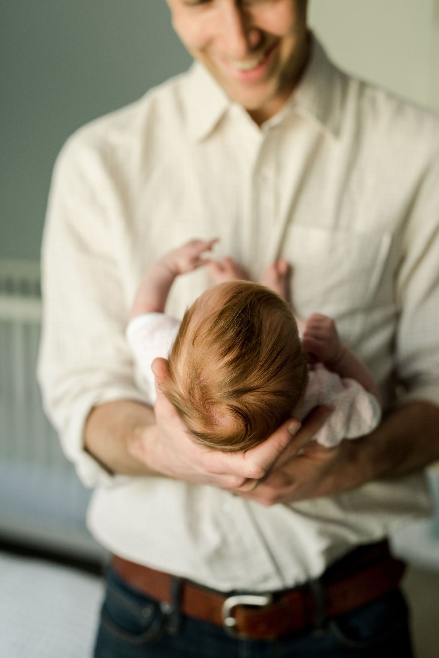 A tender moment captured with a newborn being cradled gently.