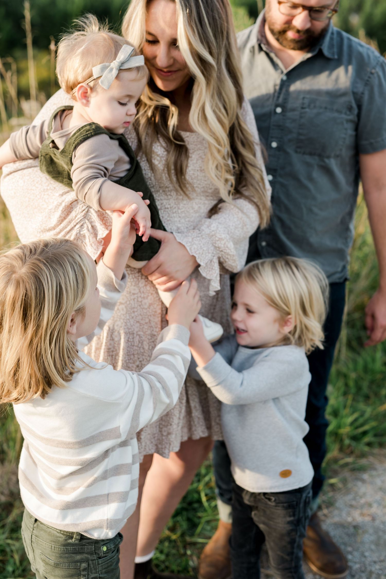 Candid outdoor family photo showing children playing and interacting in a natural setting.