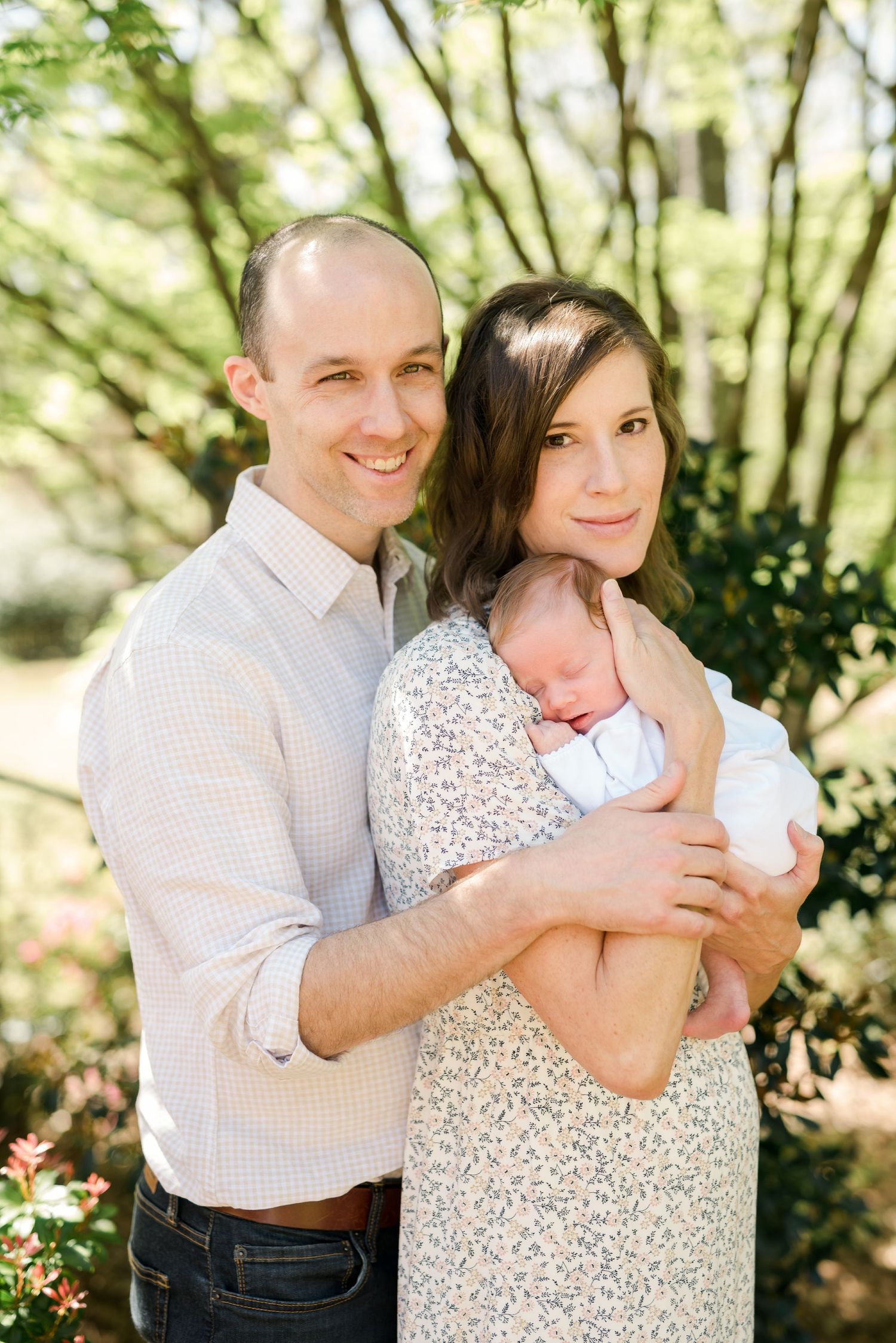 A sunny outdoor portrait with a newborn on a spring day.