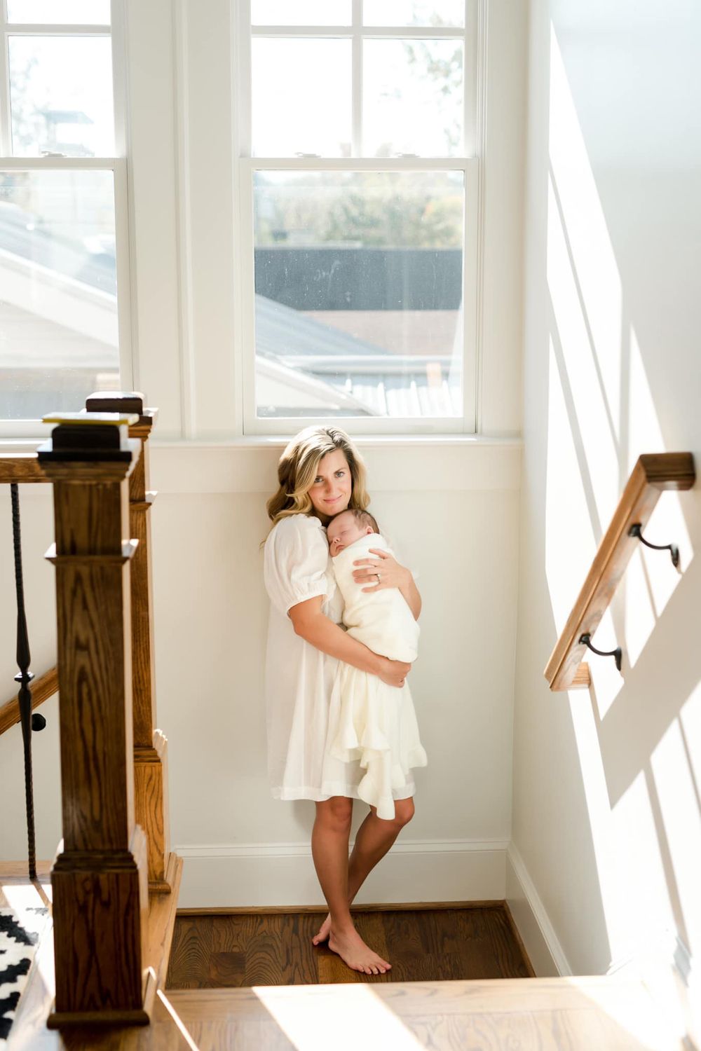 Sweet moment between parent and child with baby in woven bassinet.