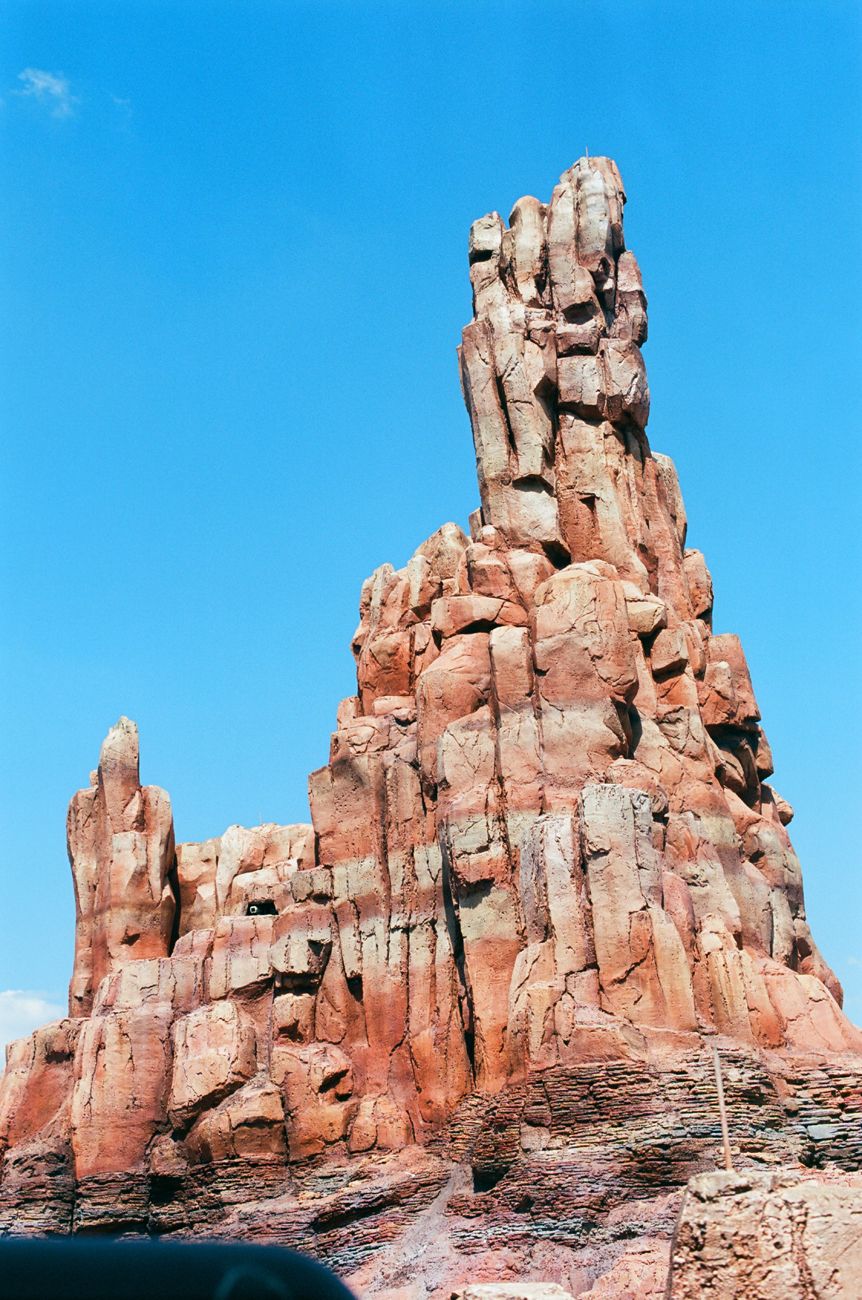 Rocky mountain formation of Big Thunder Mountain Railroad against bright blue sky at Disney World.