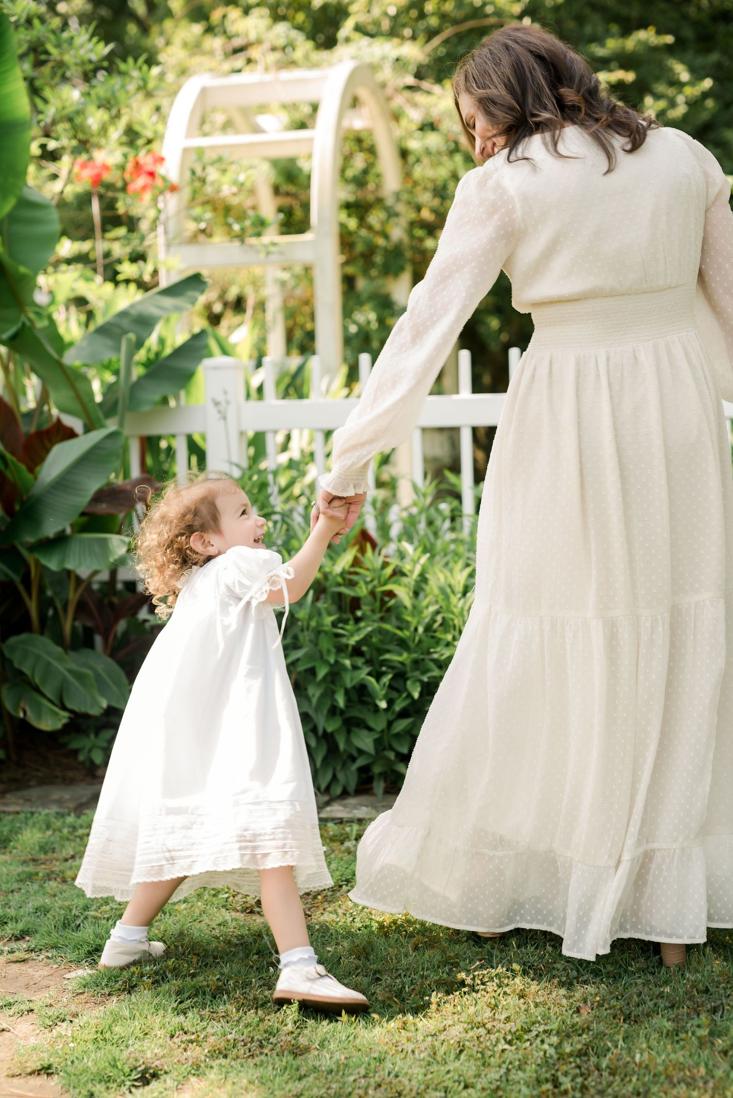 Sweet moment of connection while holding hands in a lush garden setting.