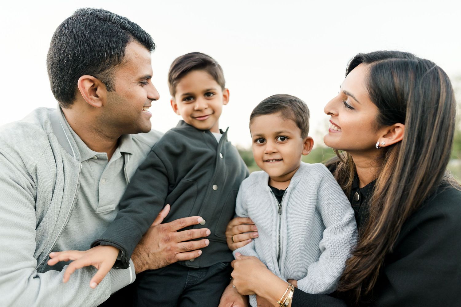 Family portrait session showing joyful interactions and embraces outdoors.