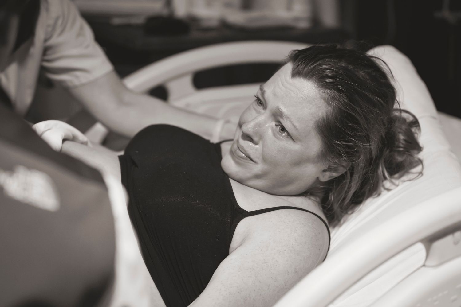 Black and white photo of a pregnant woman in labor at a hospital.