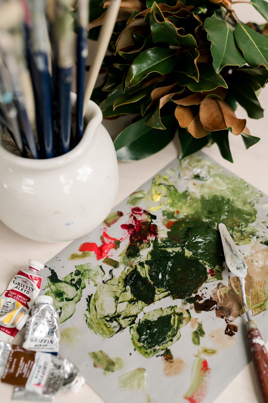 Artistic still life of scattered leaves and packaging materials on white surface.