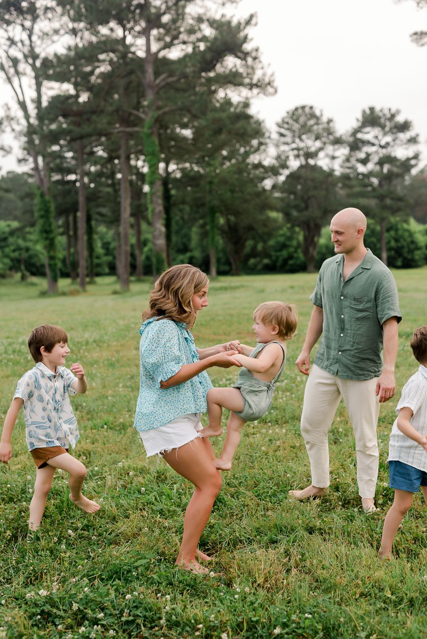 family playing together in grassy field birmingham al