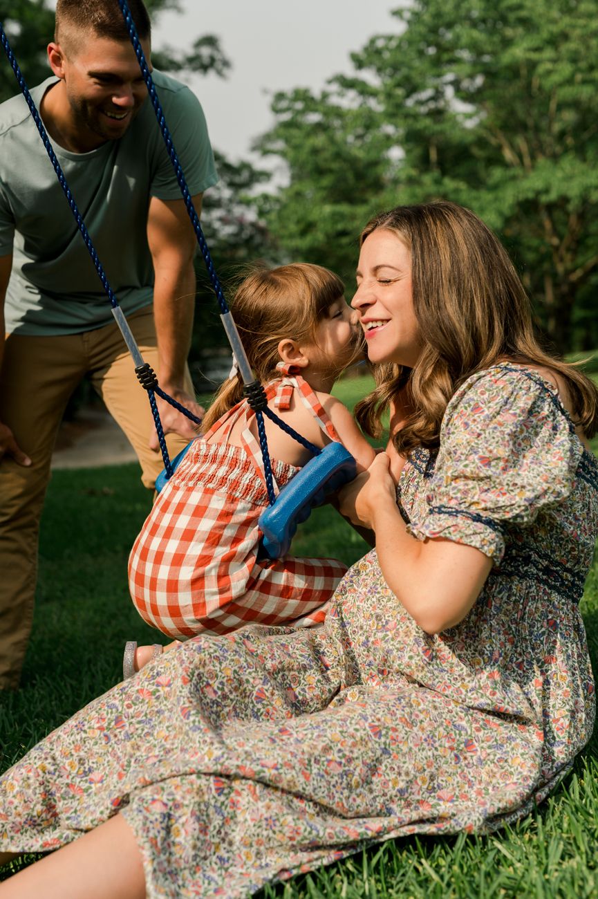 Family relaxing together on grass during a sunny outdoor photo session.
