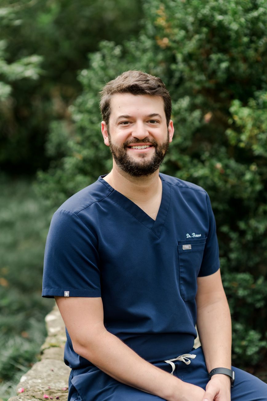 Healthcare professional in navy scrubs posing outdoors for professional headshots.