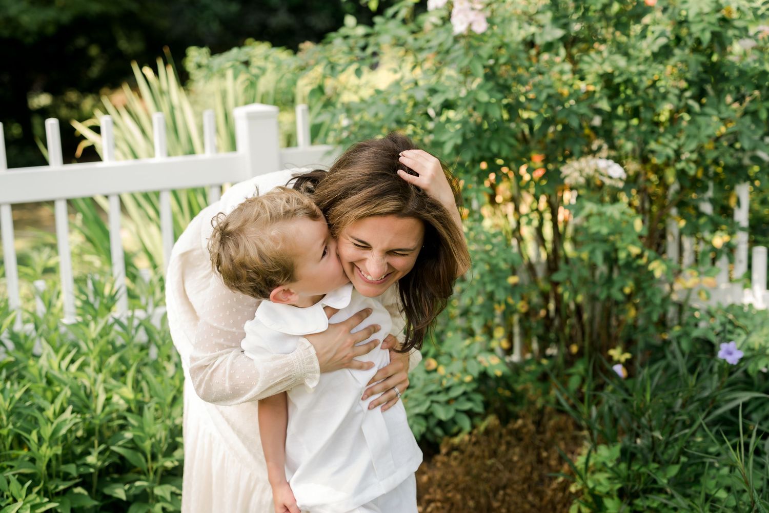 An intimate moment of affection shared in a sunny garden setting.