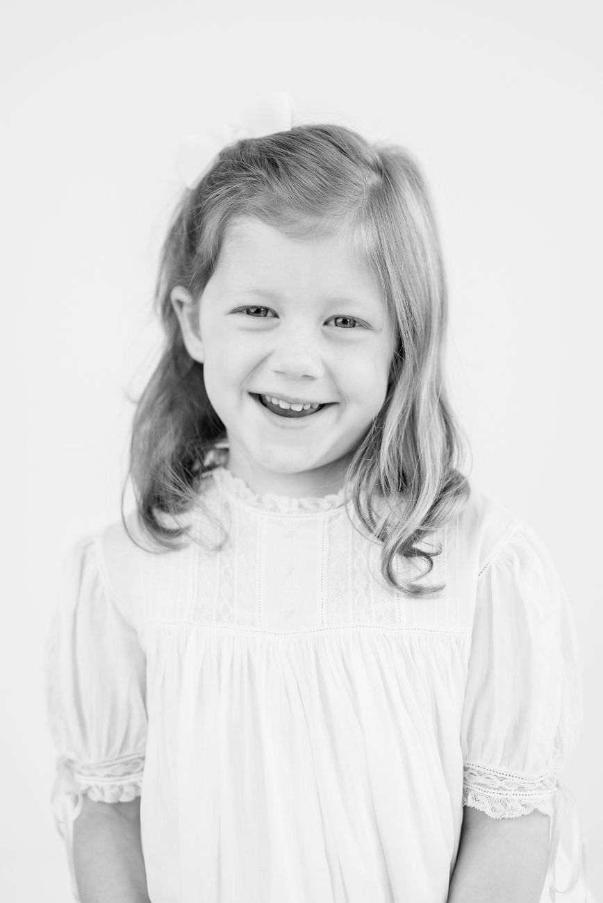 A black and white portrait showing a joyful expression against a clean white background.