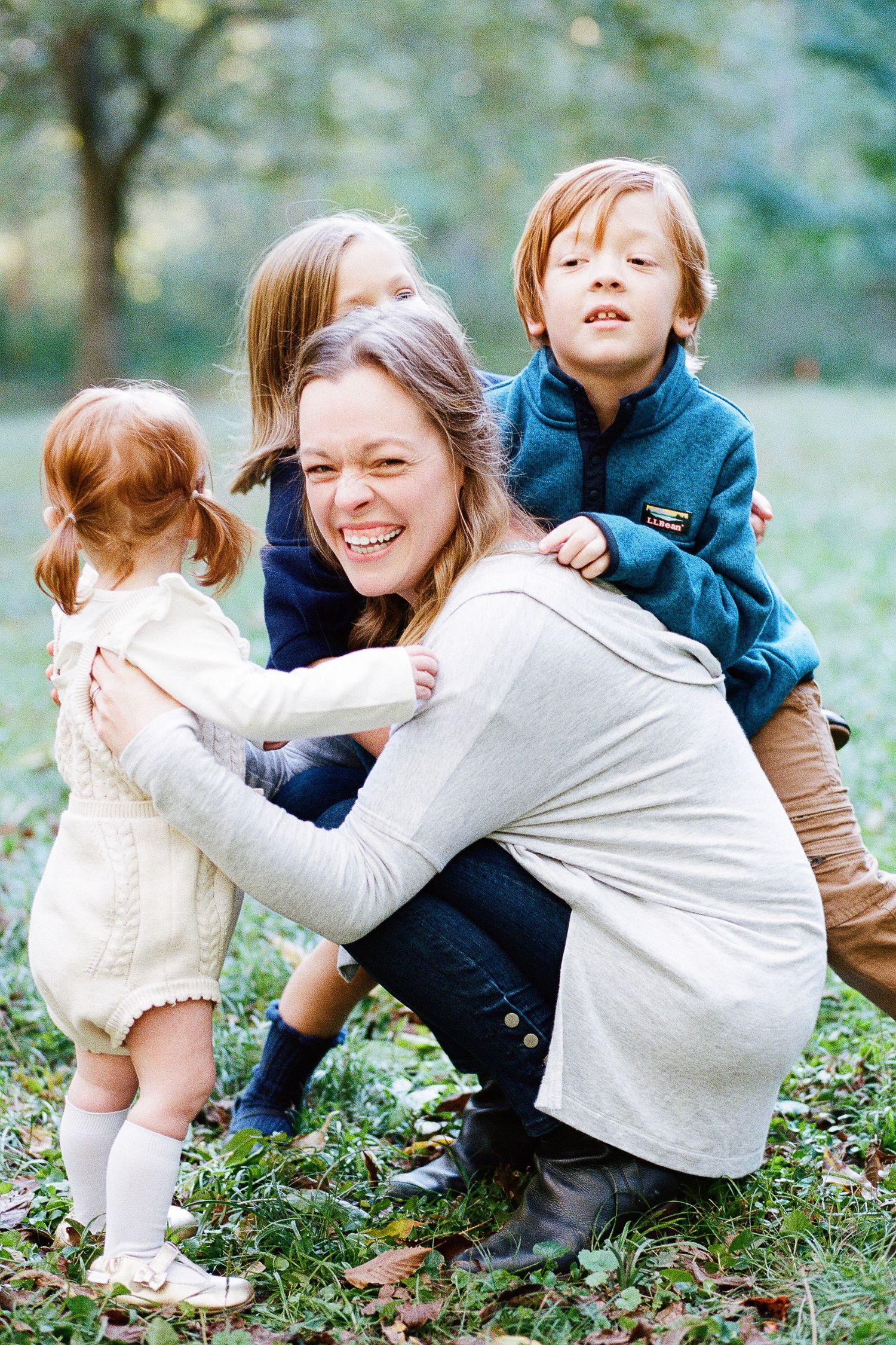 Playful outdoor family moments captured in a natural setting with autumn leaves.