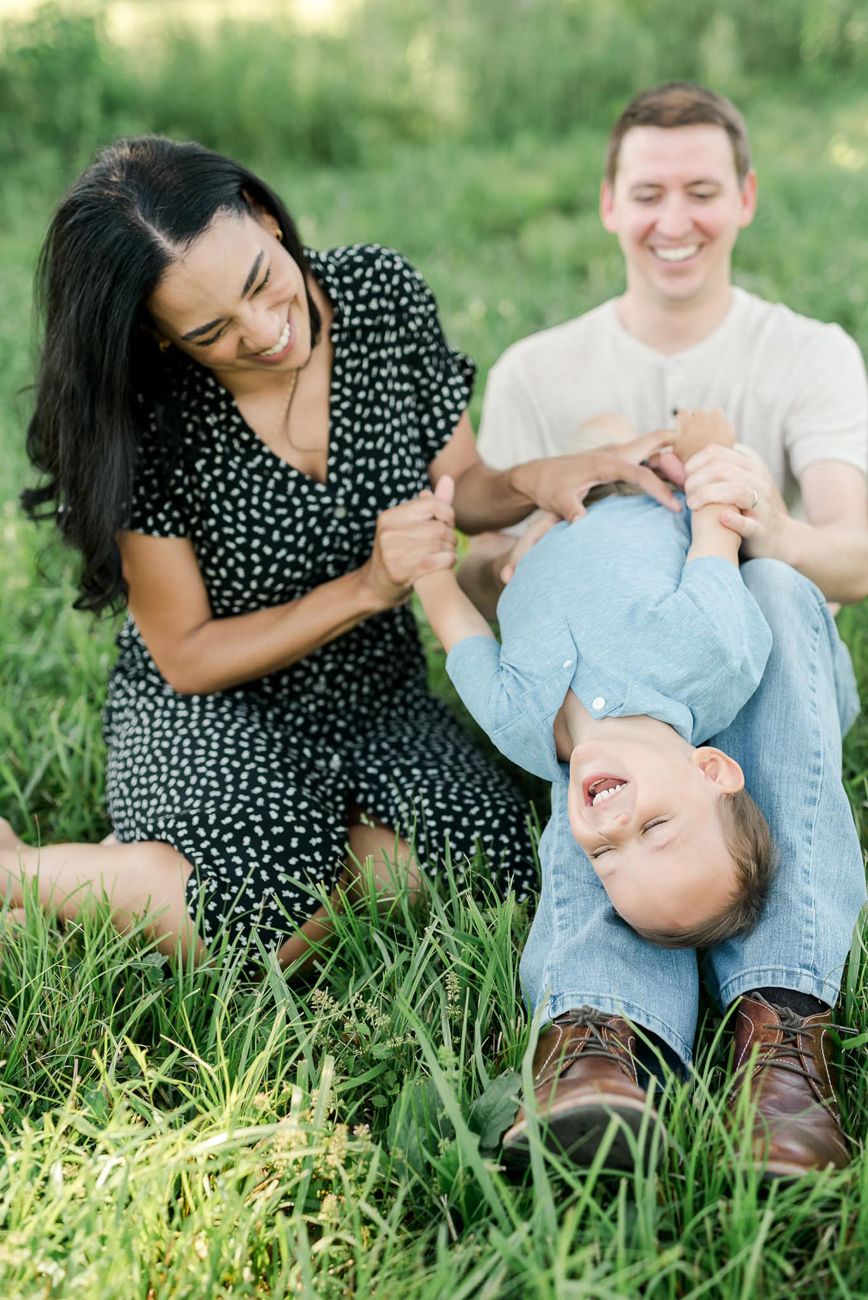 Playful couple's portrait session in green summer grass.