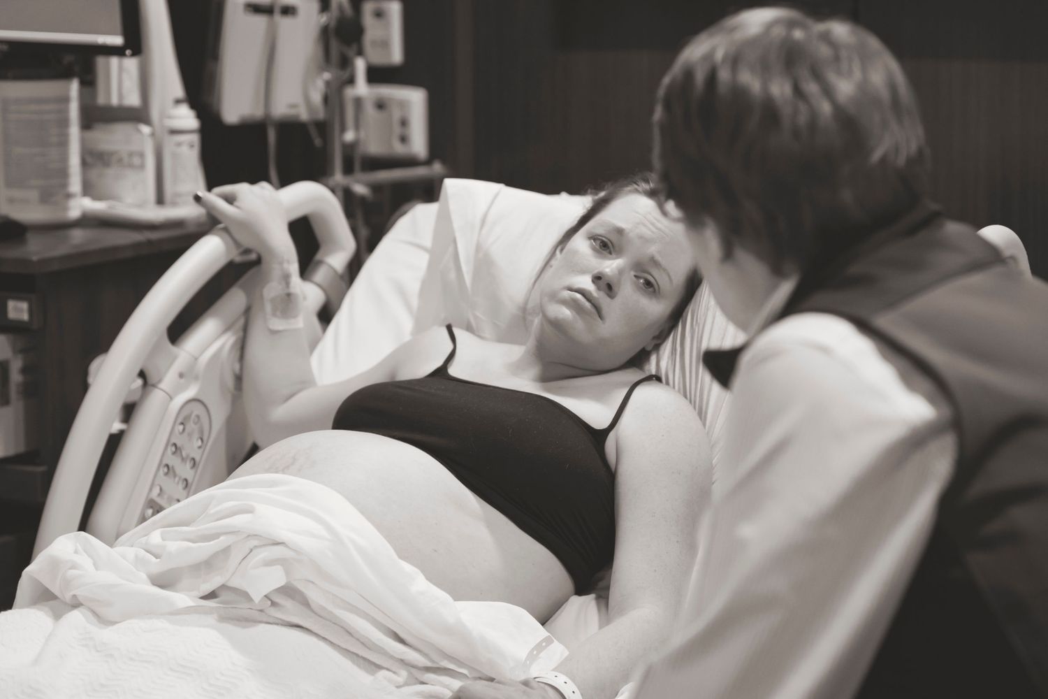 A patient rests between contractions in a hospital delivery room.