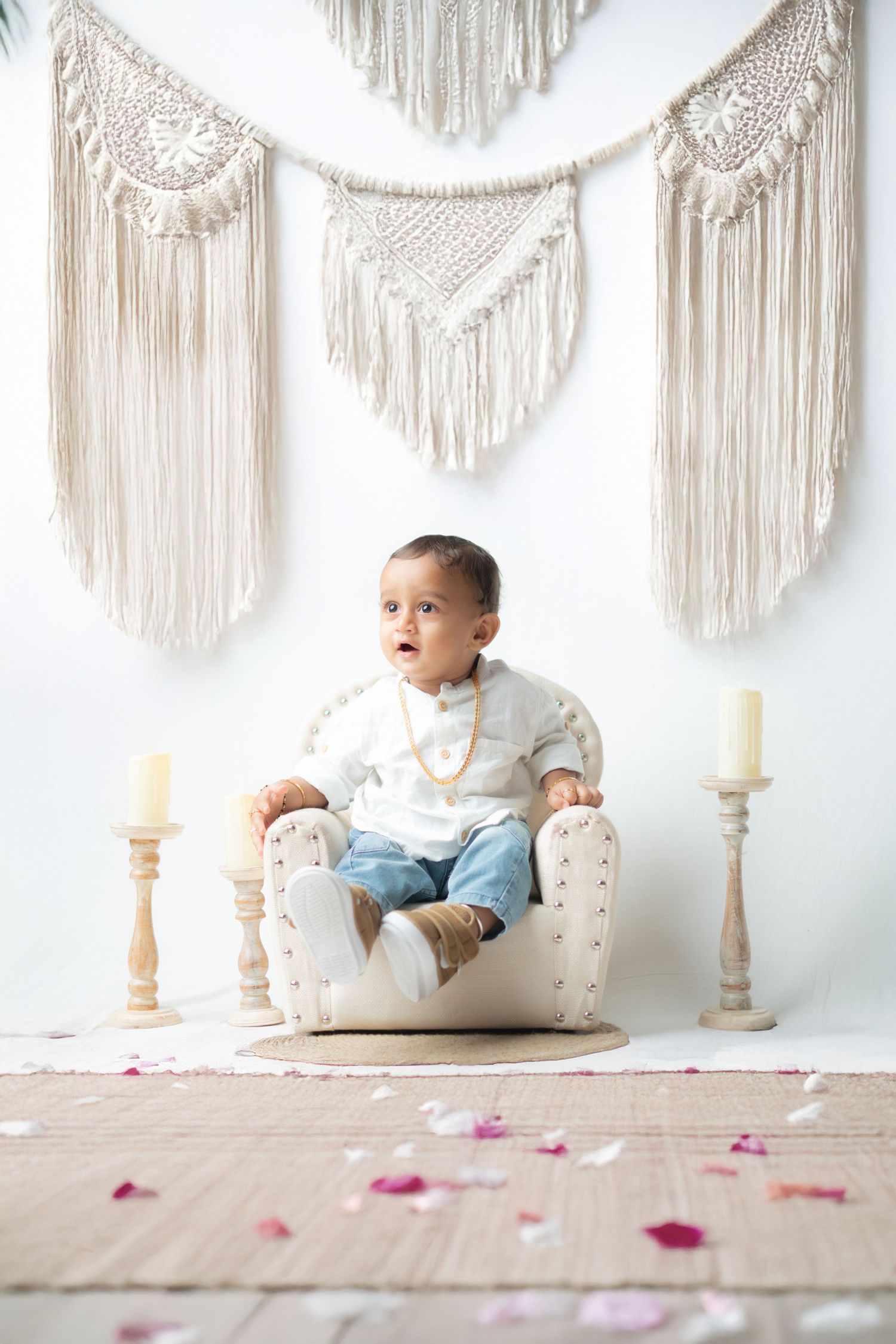 Boho style photography setup with macrame wall hangings and wooden floor.