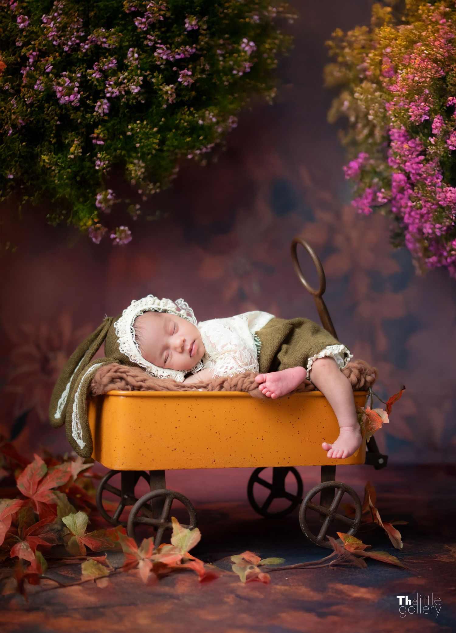 Autumn themed photo setup with orange wagon and floral decorations.