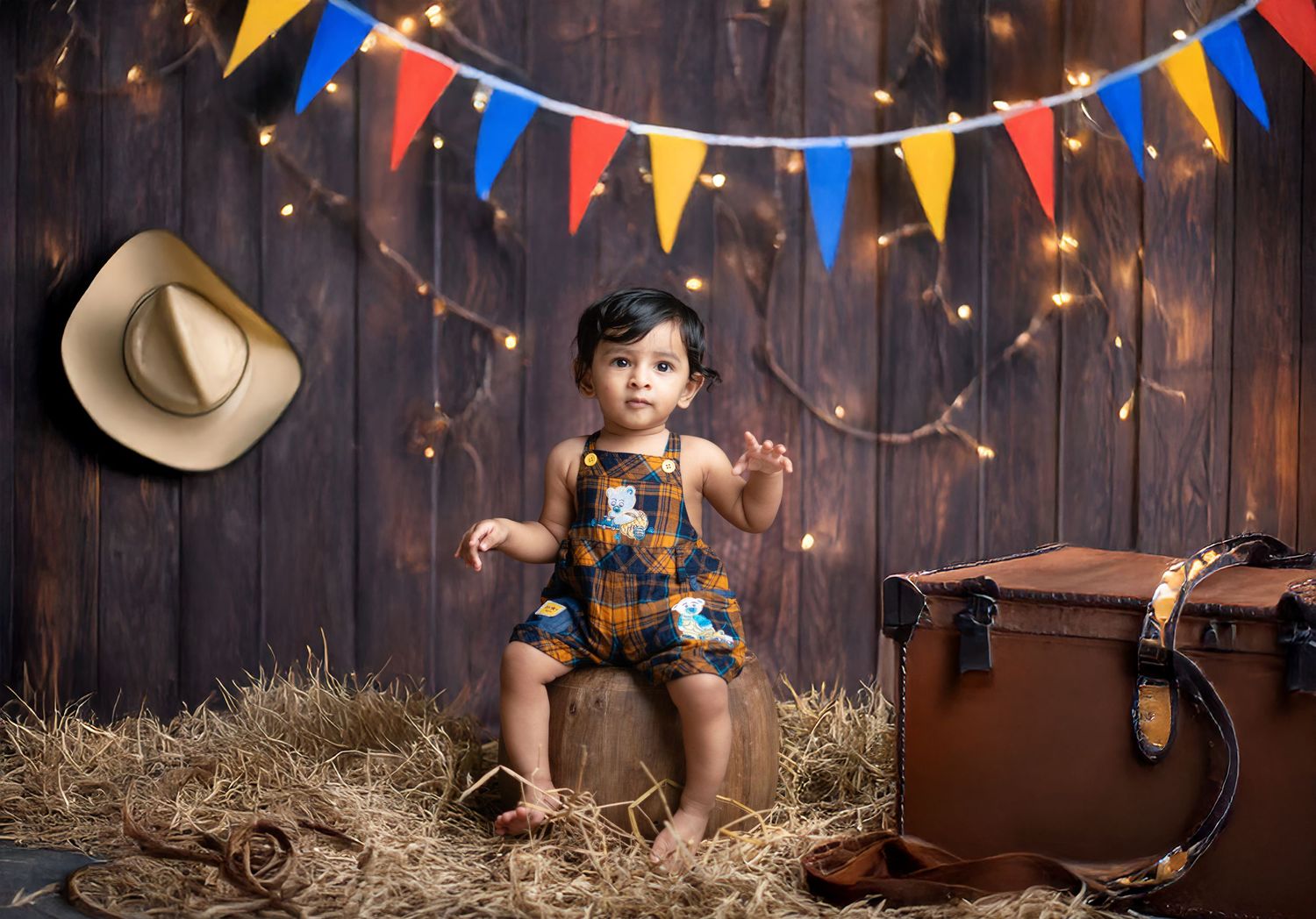 Rustic barn photography setup with colorful bunting and string lights.