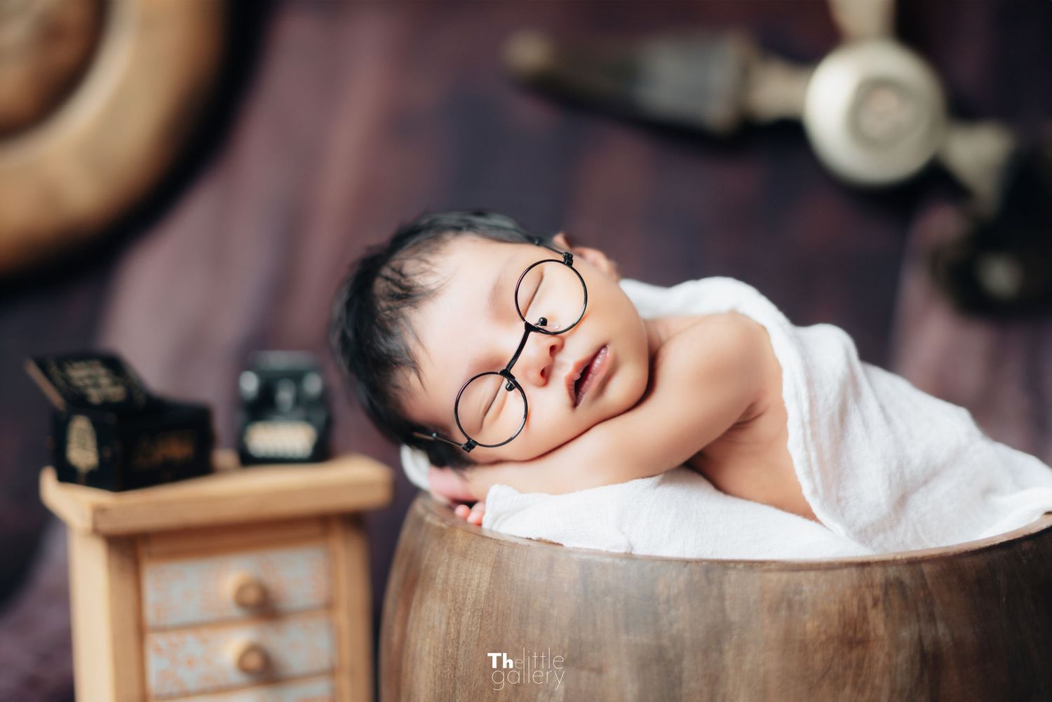 Vintage style newborn photography on antique wooden furniture.