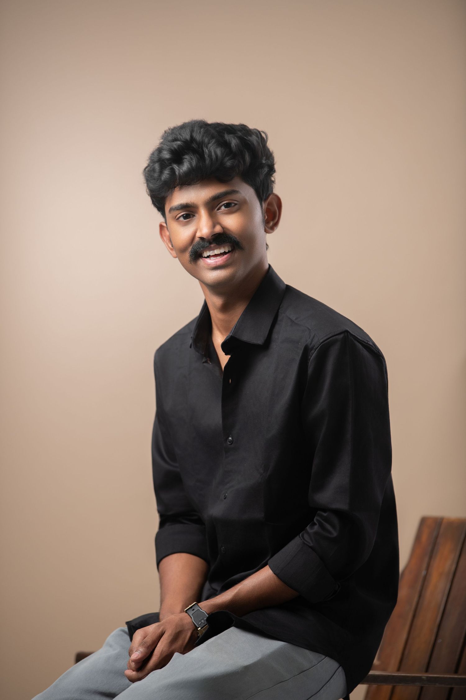 Professional studio portraits showing different expressions against a neutral brown backdrop.