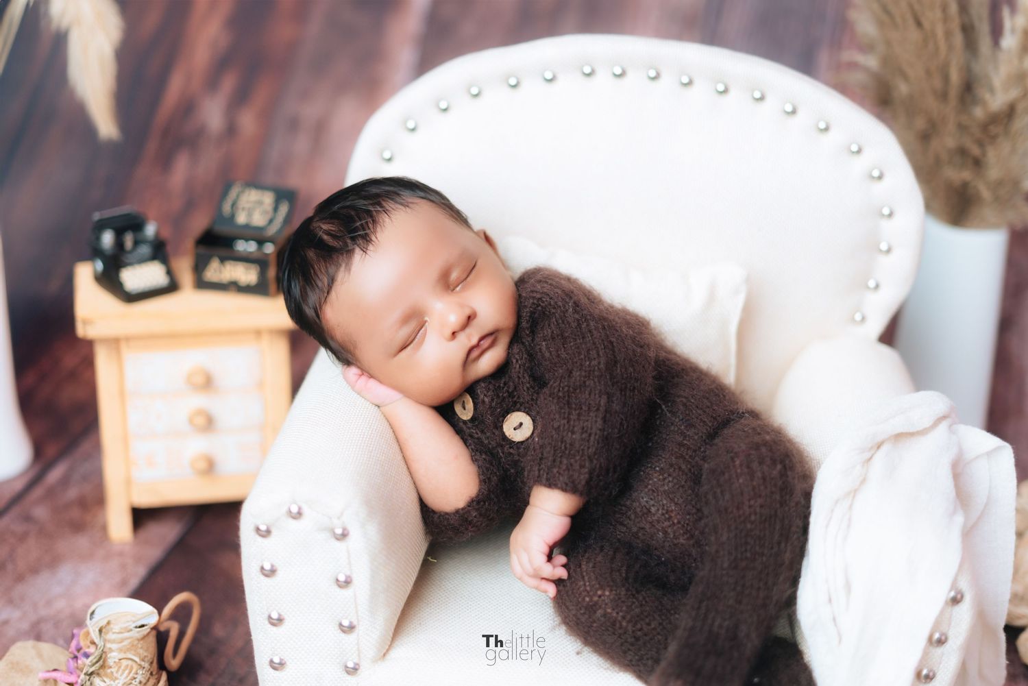 Newborn photography session featuring cozy brown blankets and wooden props in a rustic setting.