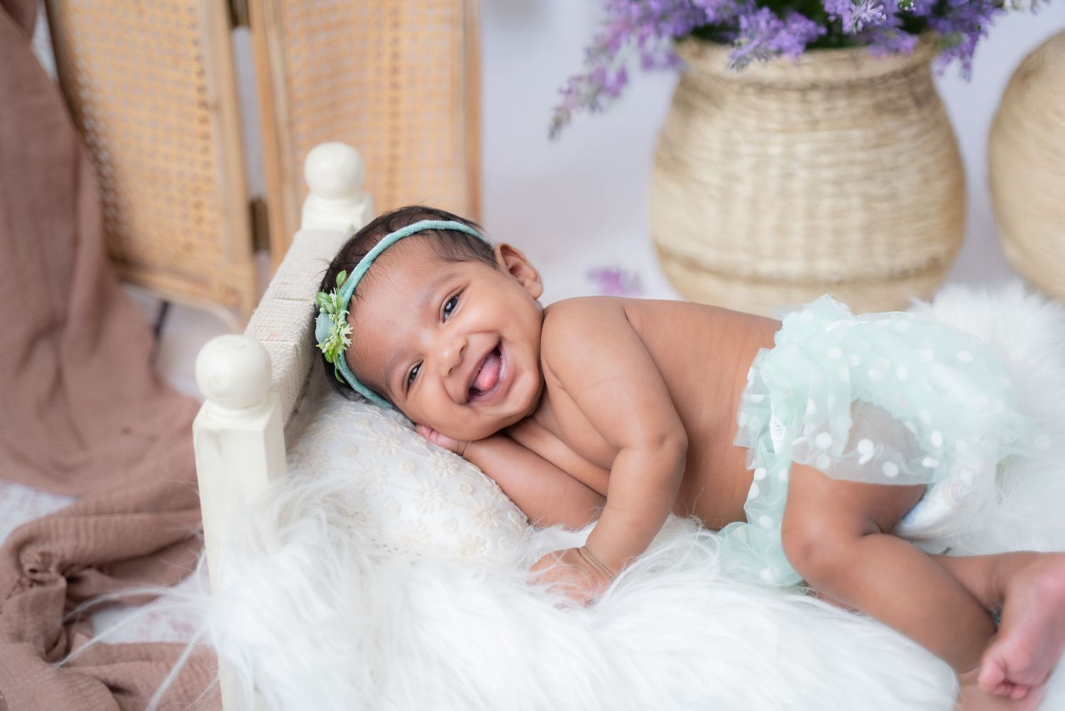 Delicate newborn photography session with soft white blankets and gentle natural lighting.