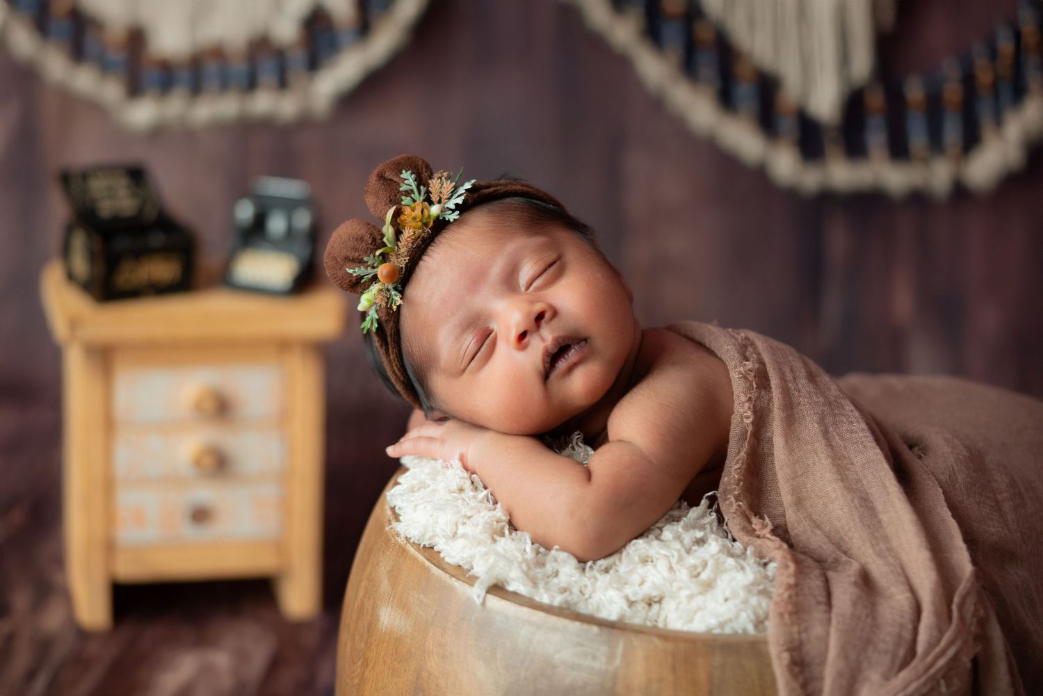 Peaceful newborn sleeping on wooden surface with vintage decor.