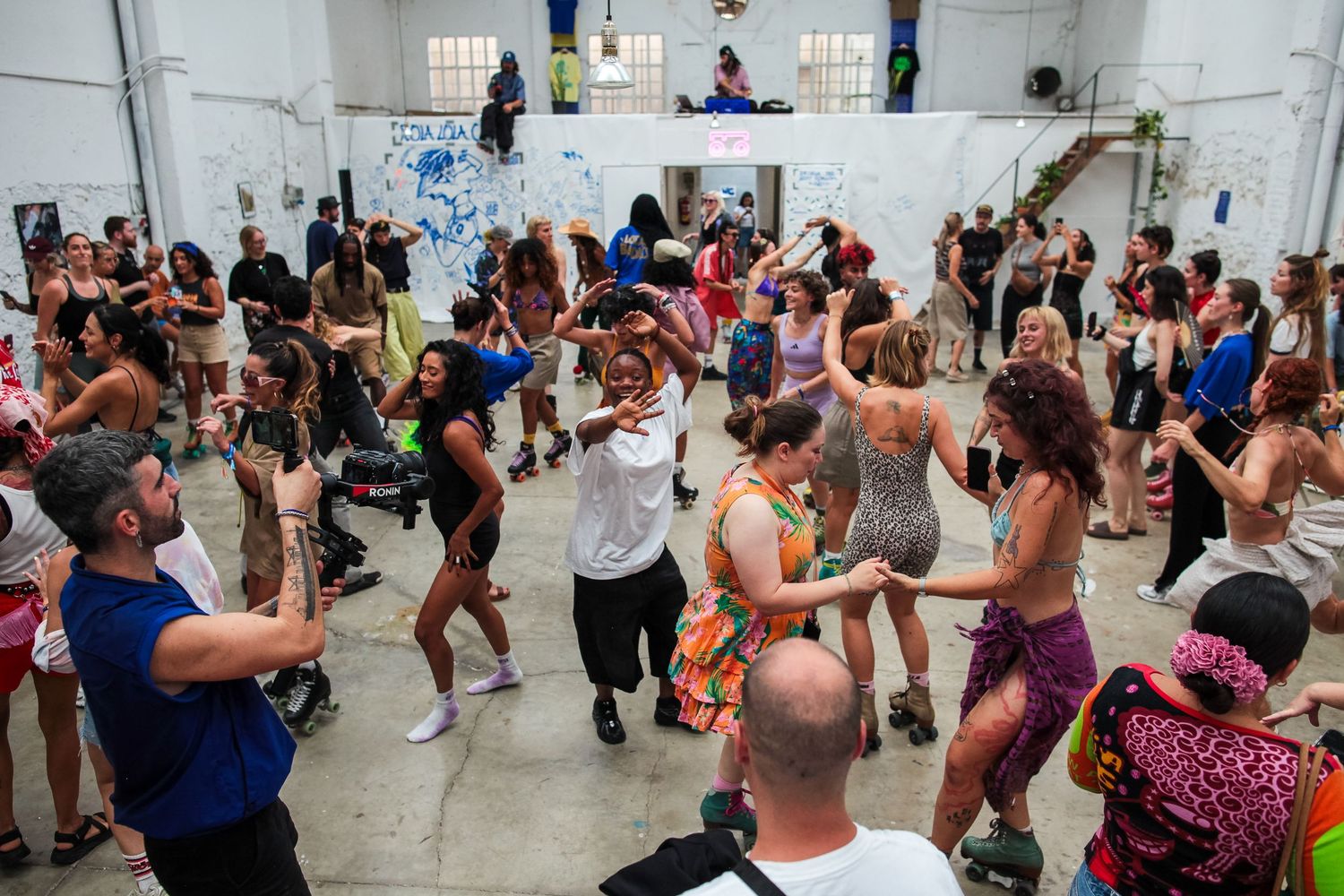 Crowded dance workshop with participants following choreography in a white-walled studio.
