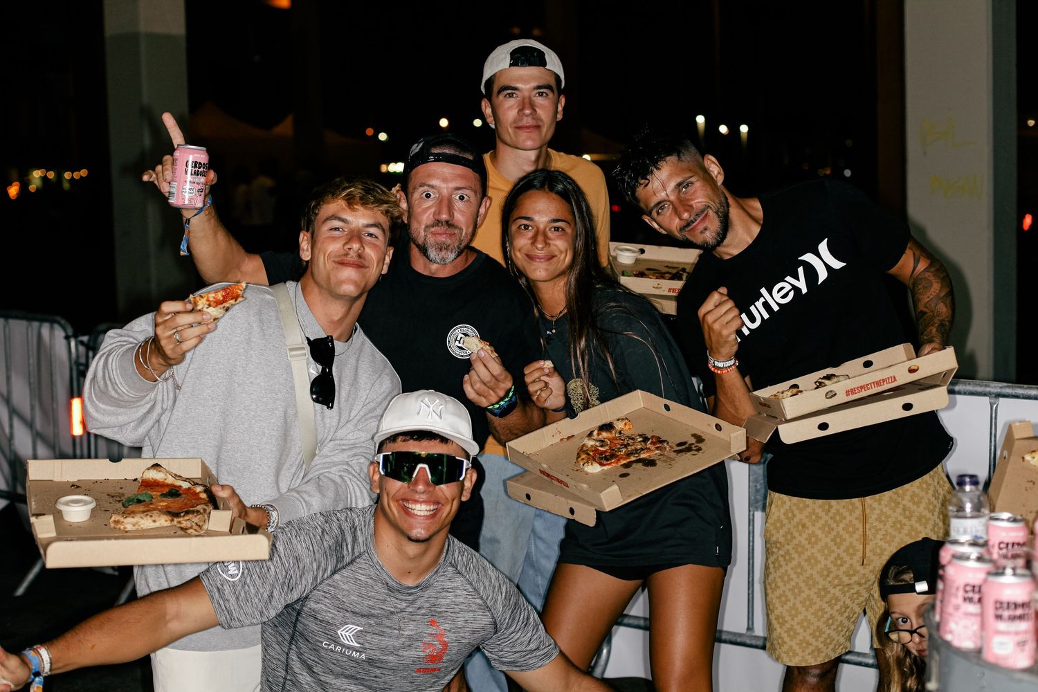 Friends enjoying pizza and drinks together at a casual restaurant gathering.