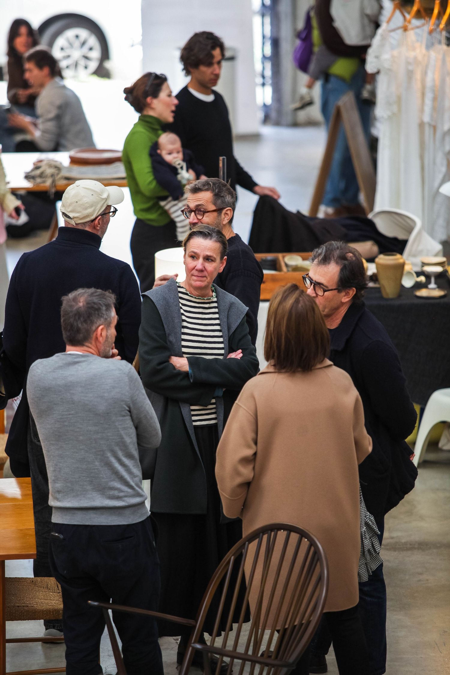 People seated at tables having conversations in a modern industrial-style space.