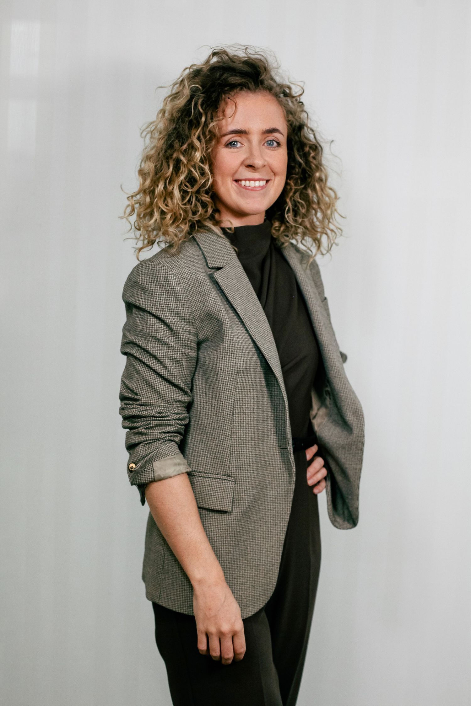 Professional portrait series showing a person in a gray blazer and black top against a light background.