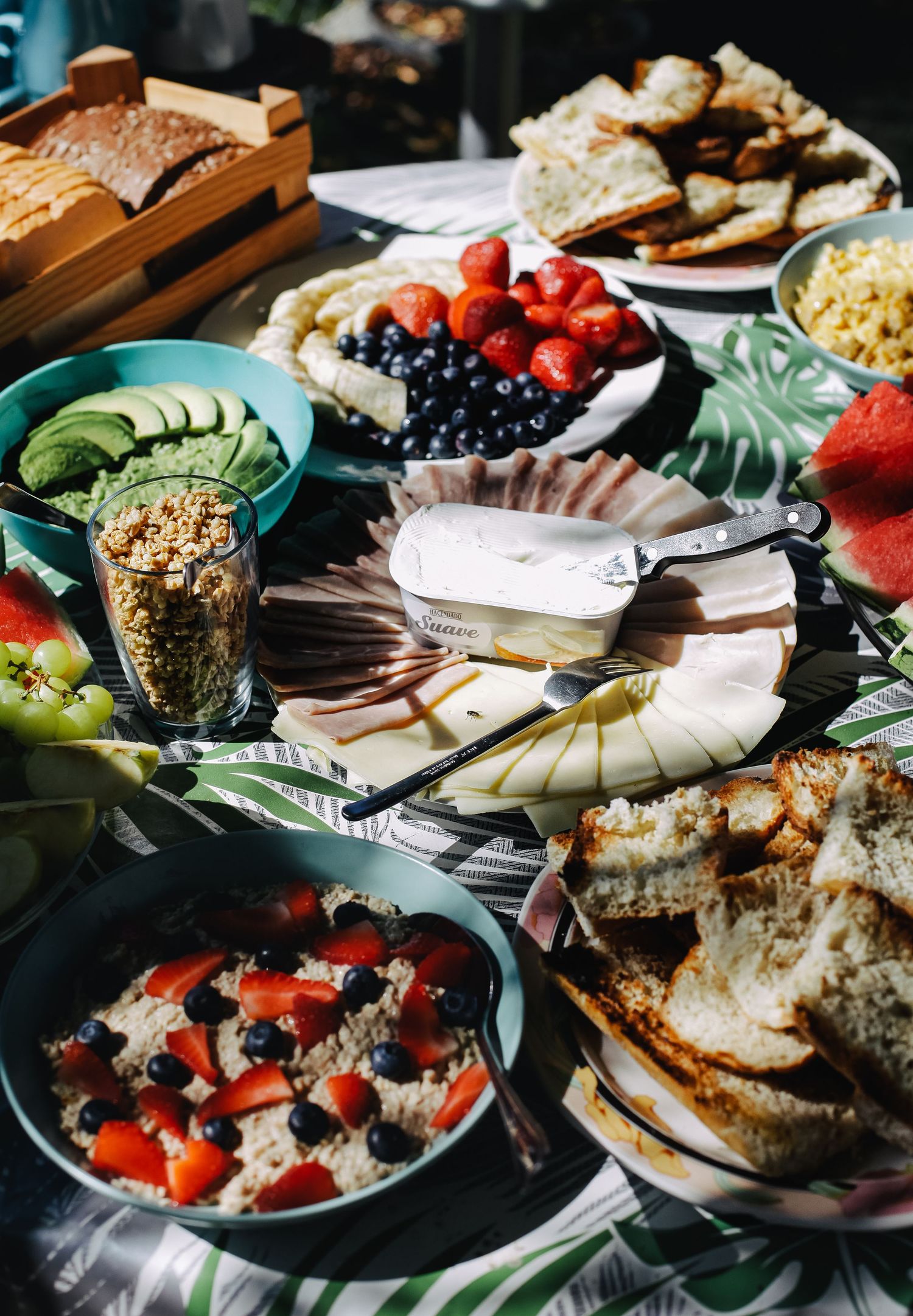 Colorful brunch spread with fresh fruits, pastries and dishes on decorated table.