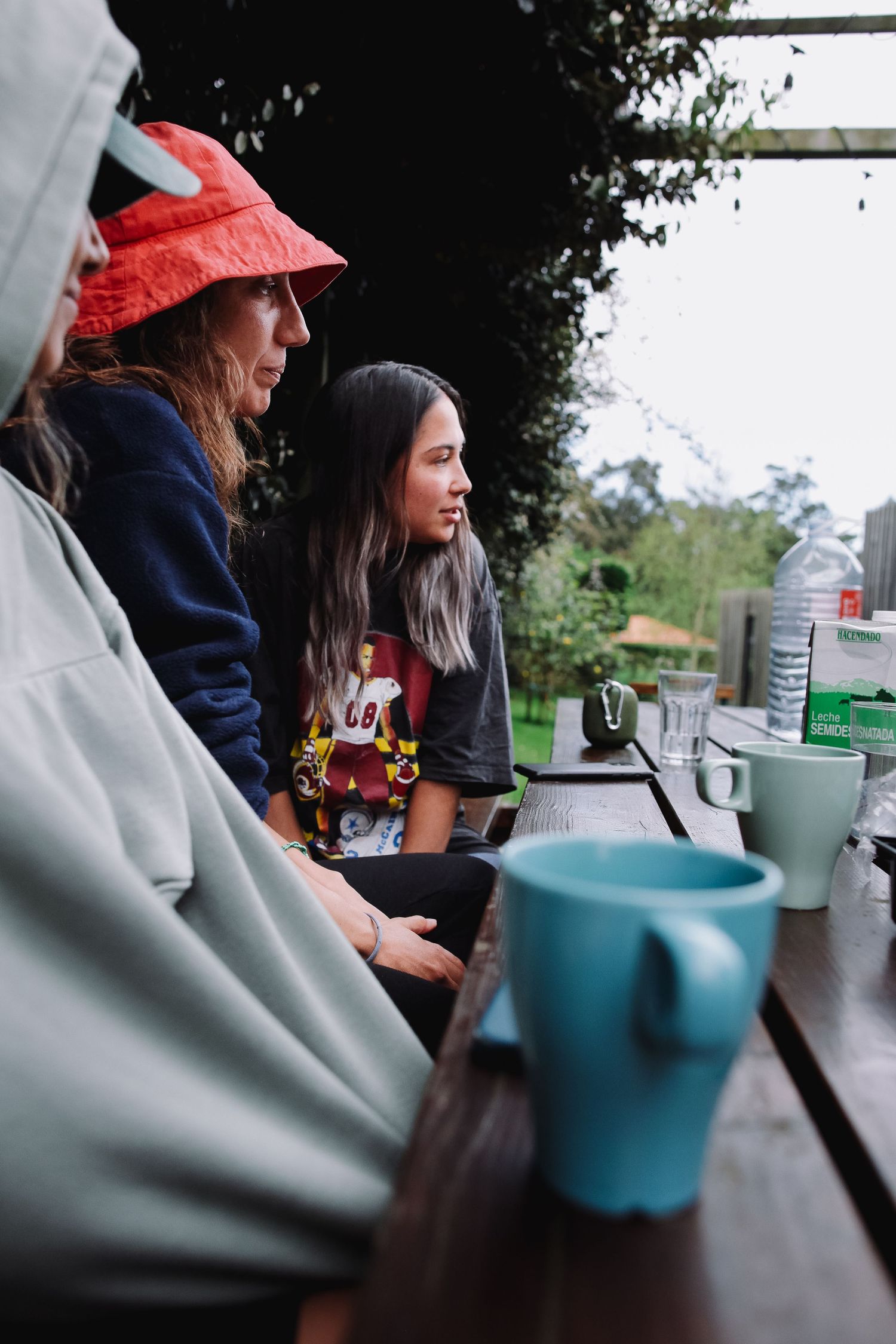 People enjoying hot drinks at an outdoor cafe table.