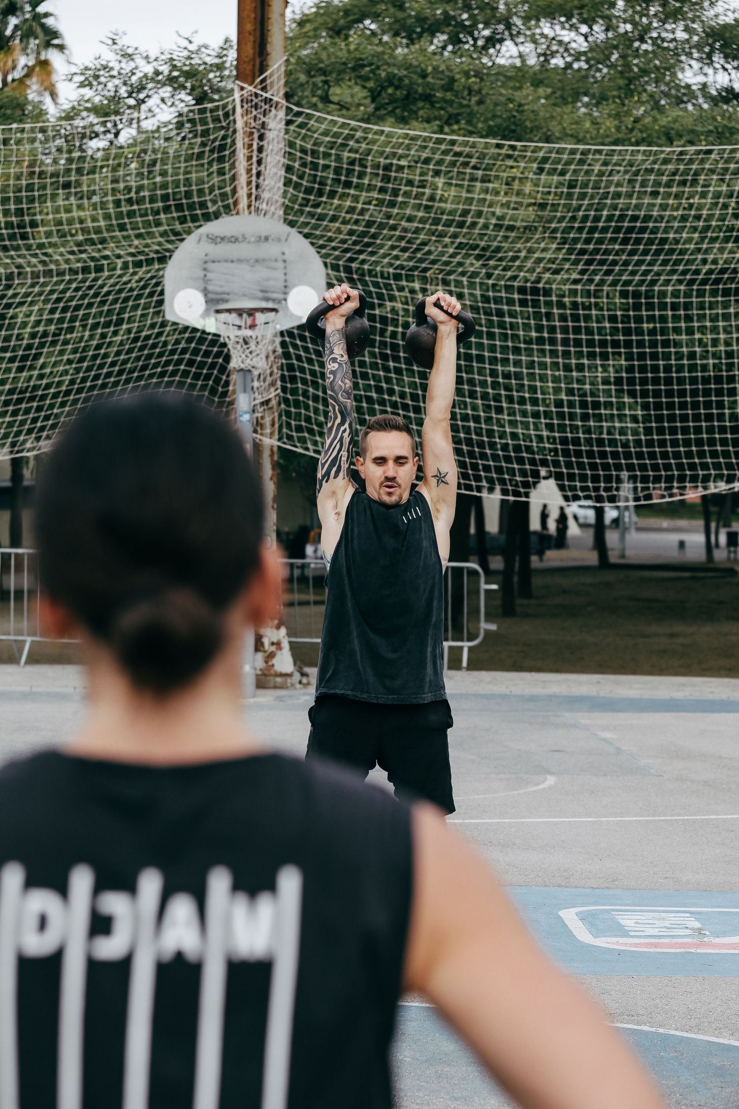 Basketball players lined up for practice drills on an outdoor court.