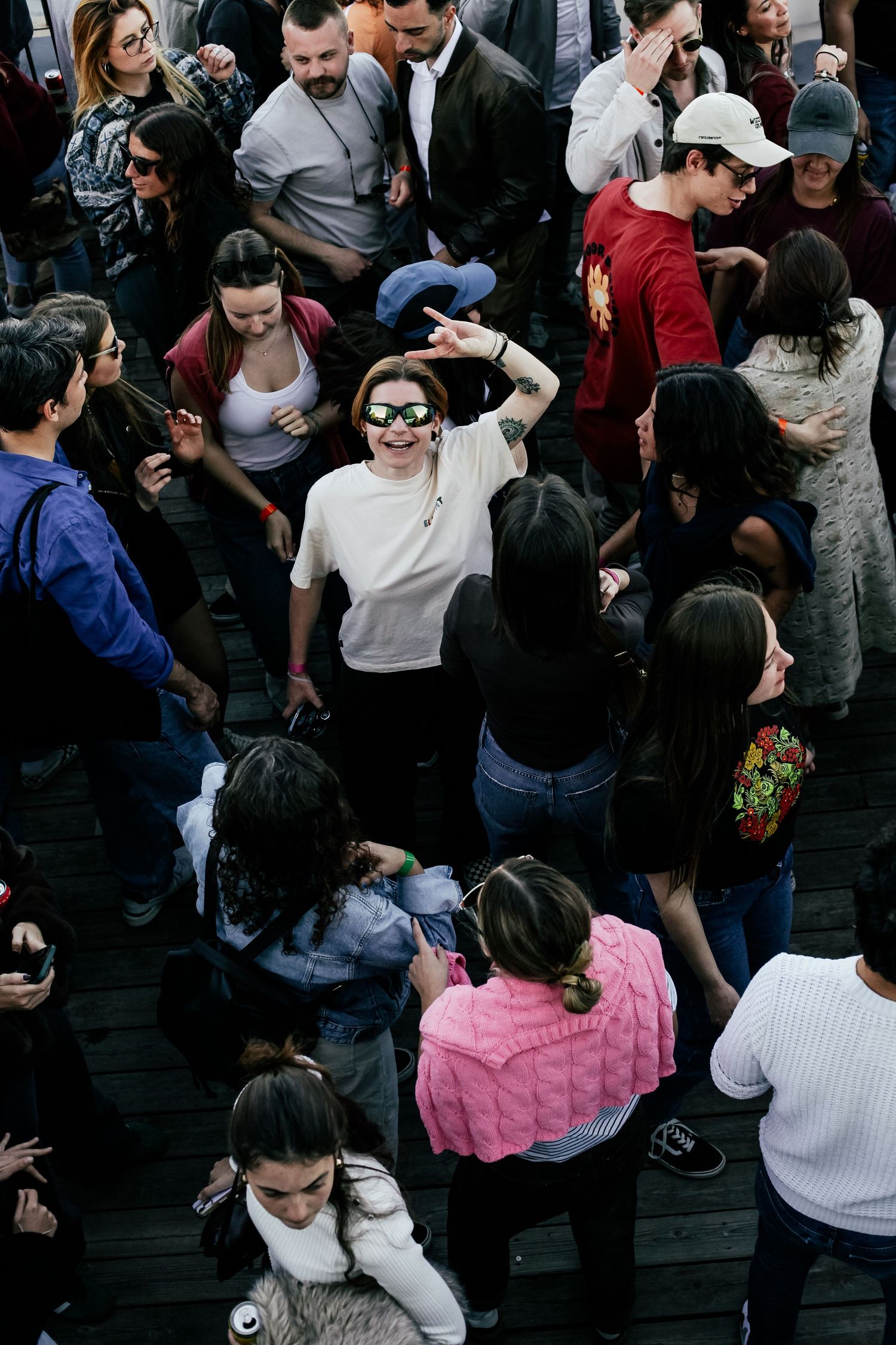 Crowded dance party with people moving and socializing on a dark dance floor.