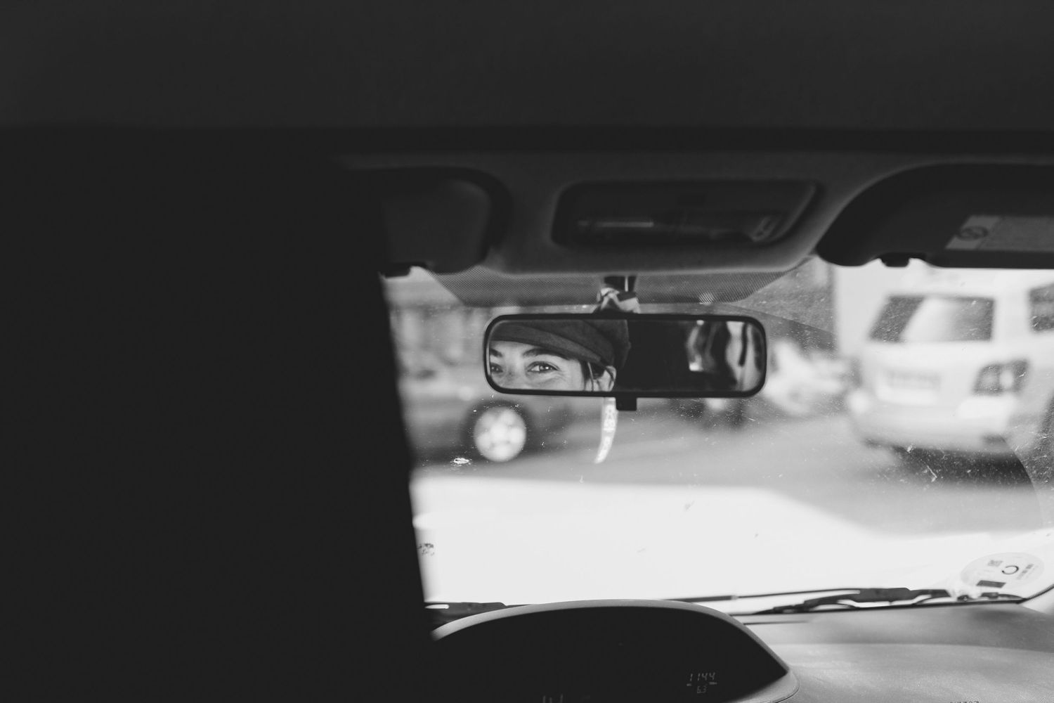 Blurred black and white view through a car windshield at night.