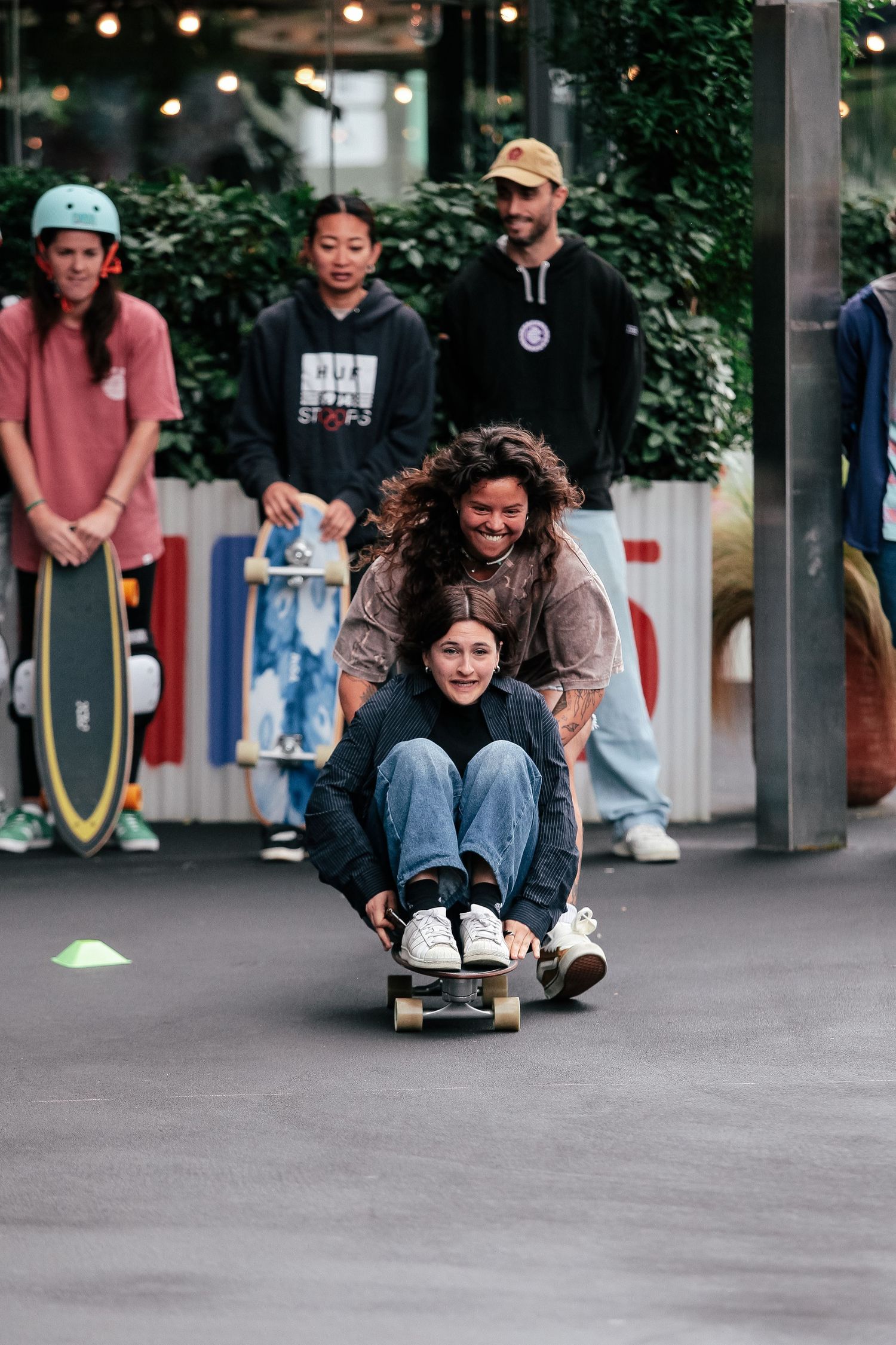People riding skateboards and longboards down a paved path.