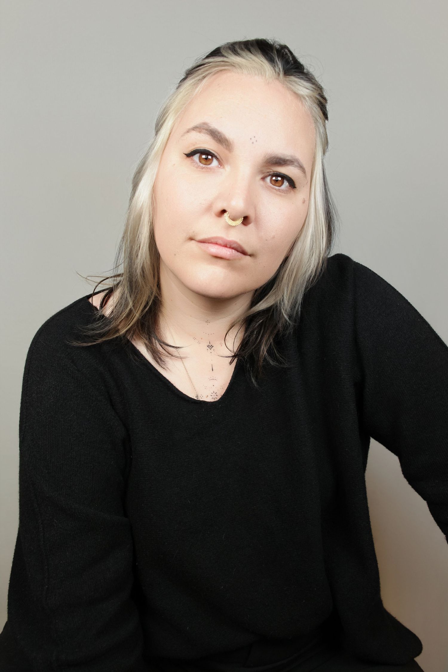 Studio portrait series showing expressive poses in black sweater against grey background.