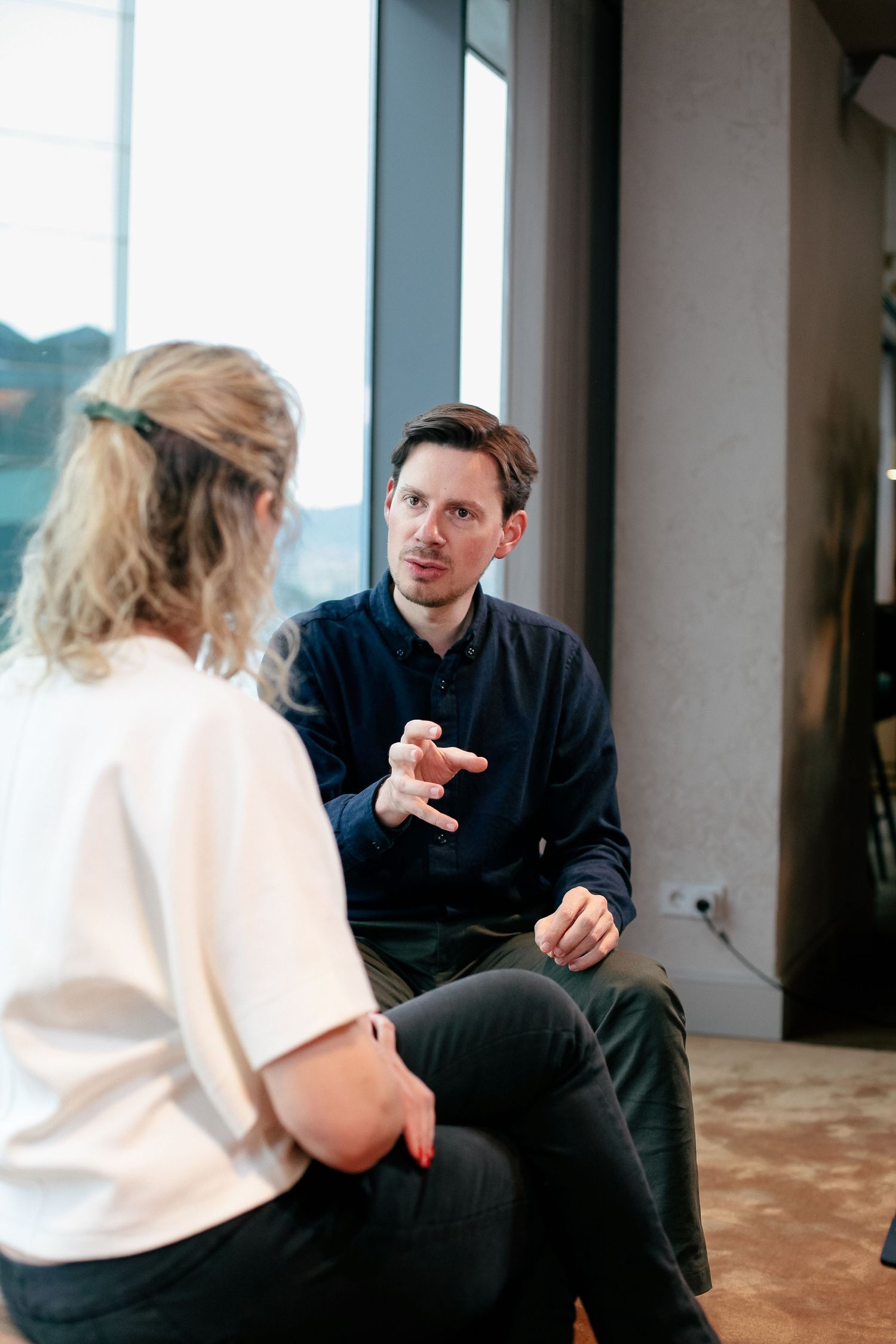 Professional meeting between two people having animated discussion in modern office space.