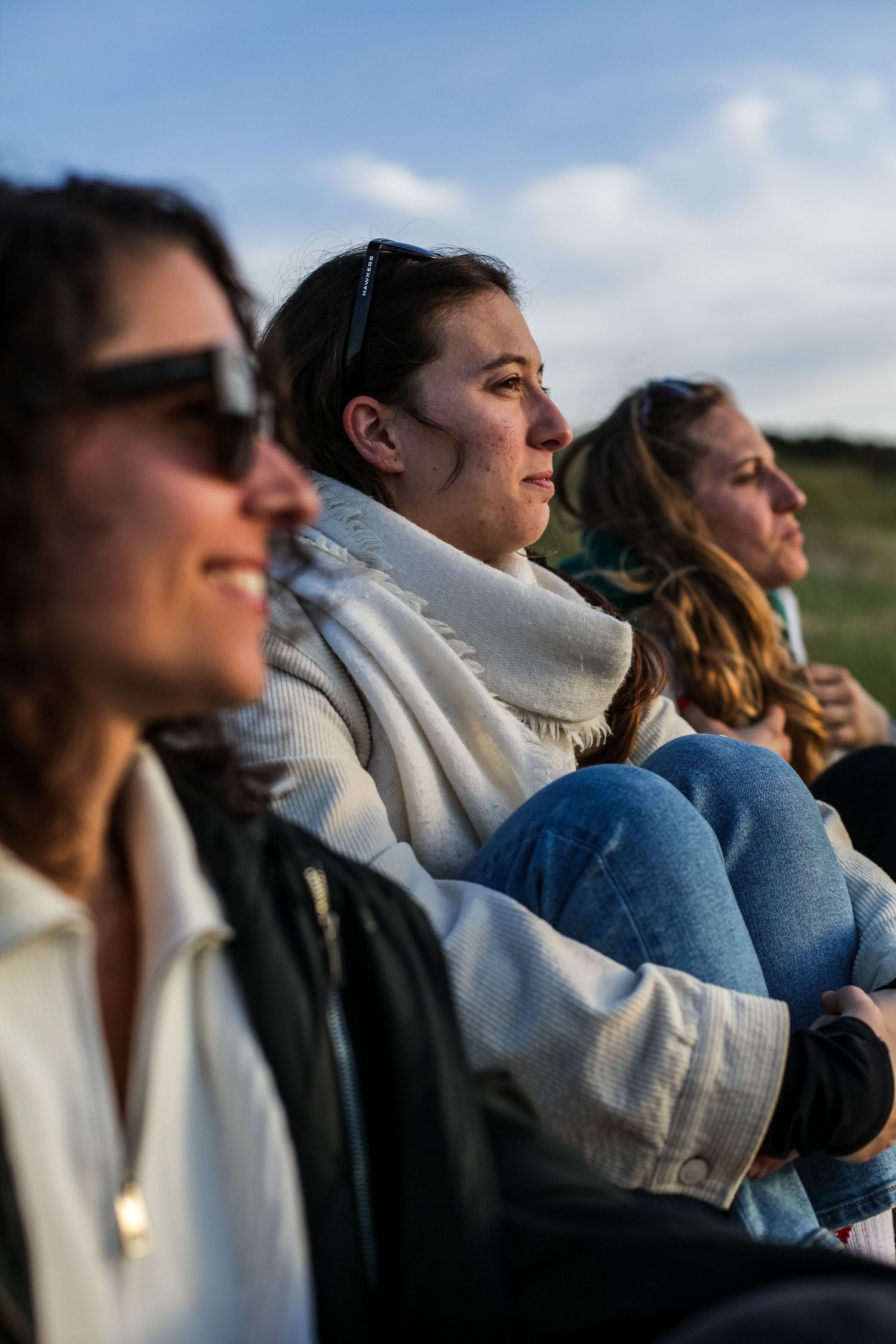 People sitting outdoors enjoying a scenic view at sunset.