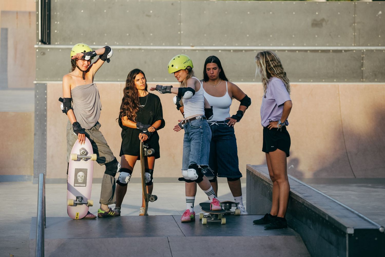 A group of people sitting and relaxing on a concrete ledge in an outdoor setting.