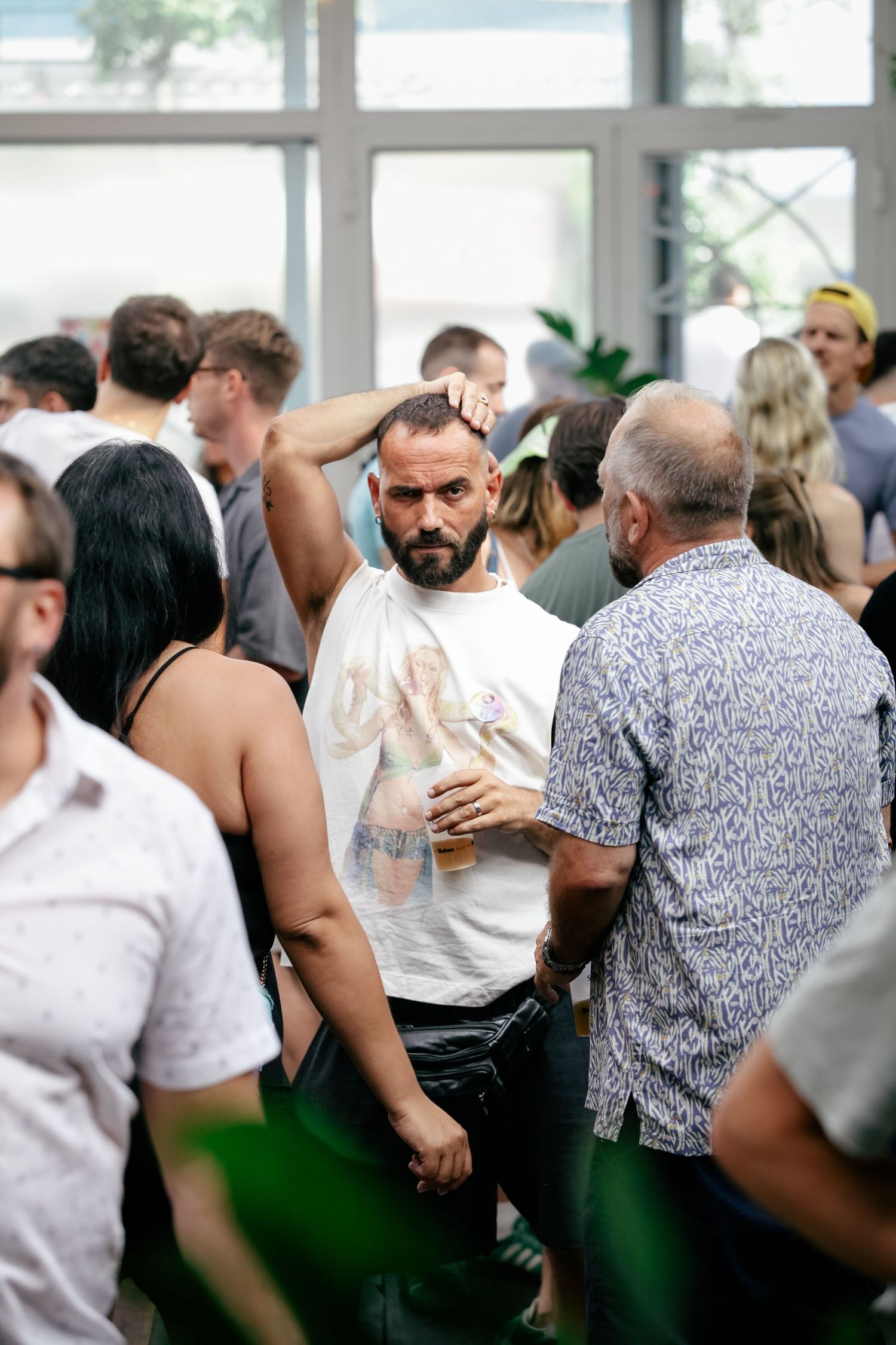 People gathered at an indoor event space with white walls and large windows.