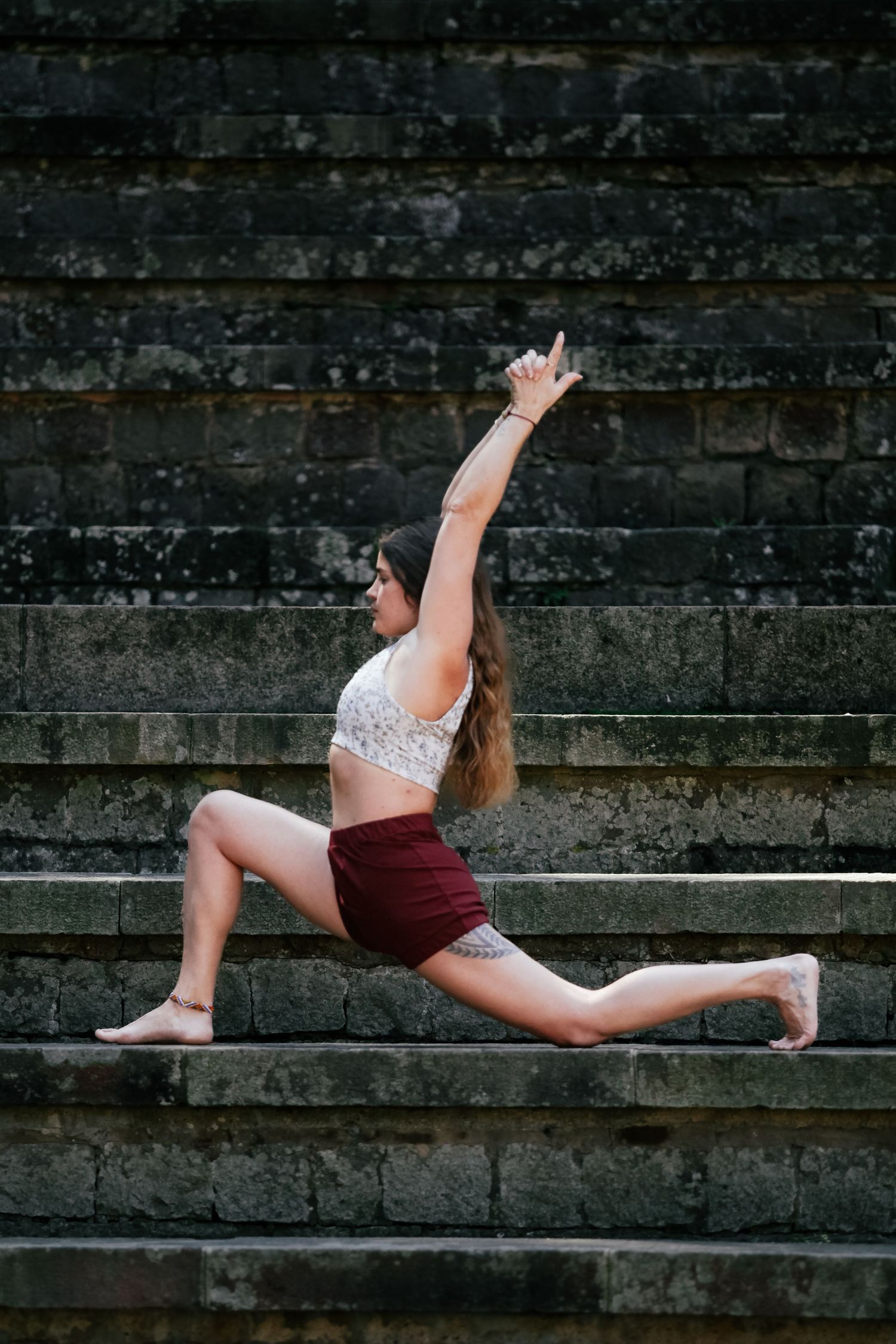 Dancer performing graceful splits pose on dark stone steps in artistic photoshoot.