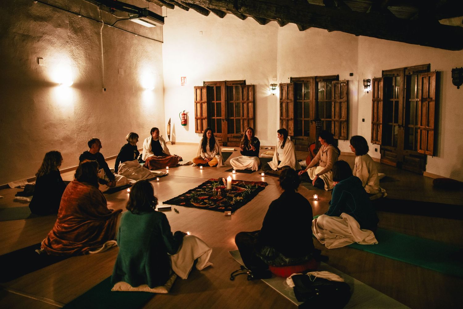 People sitting in a dimly lit room with warm ambient lighting.