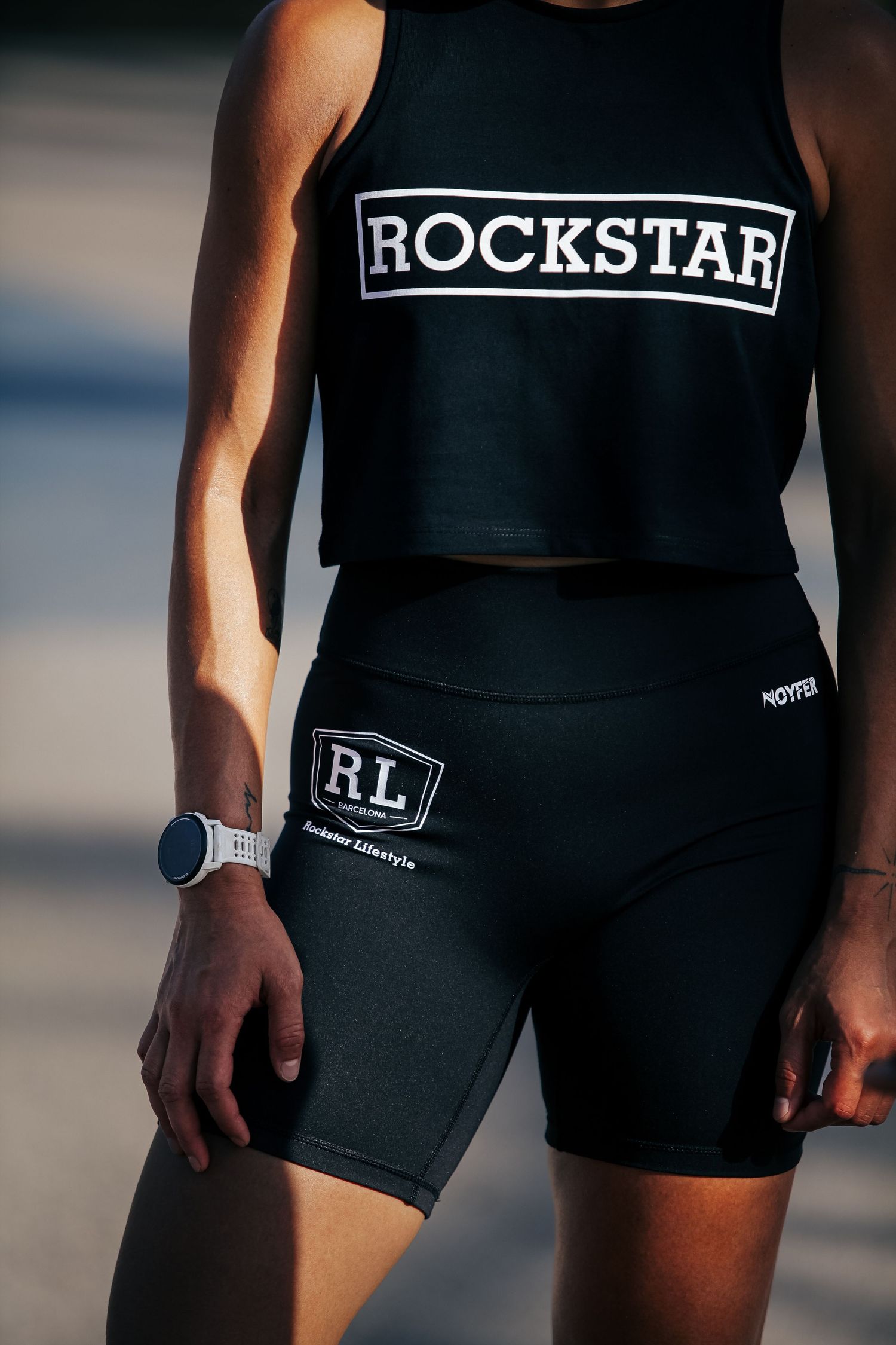 Athletic wear featuring black Rockstar crop top and matching bike shorts with white text.