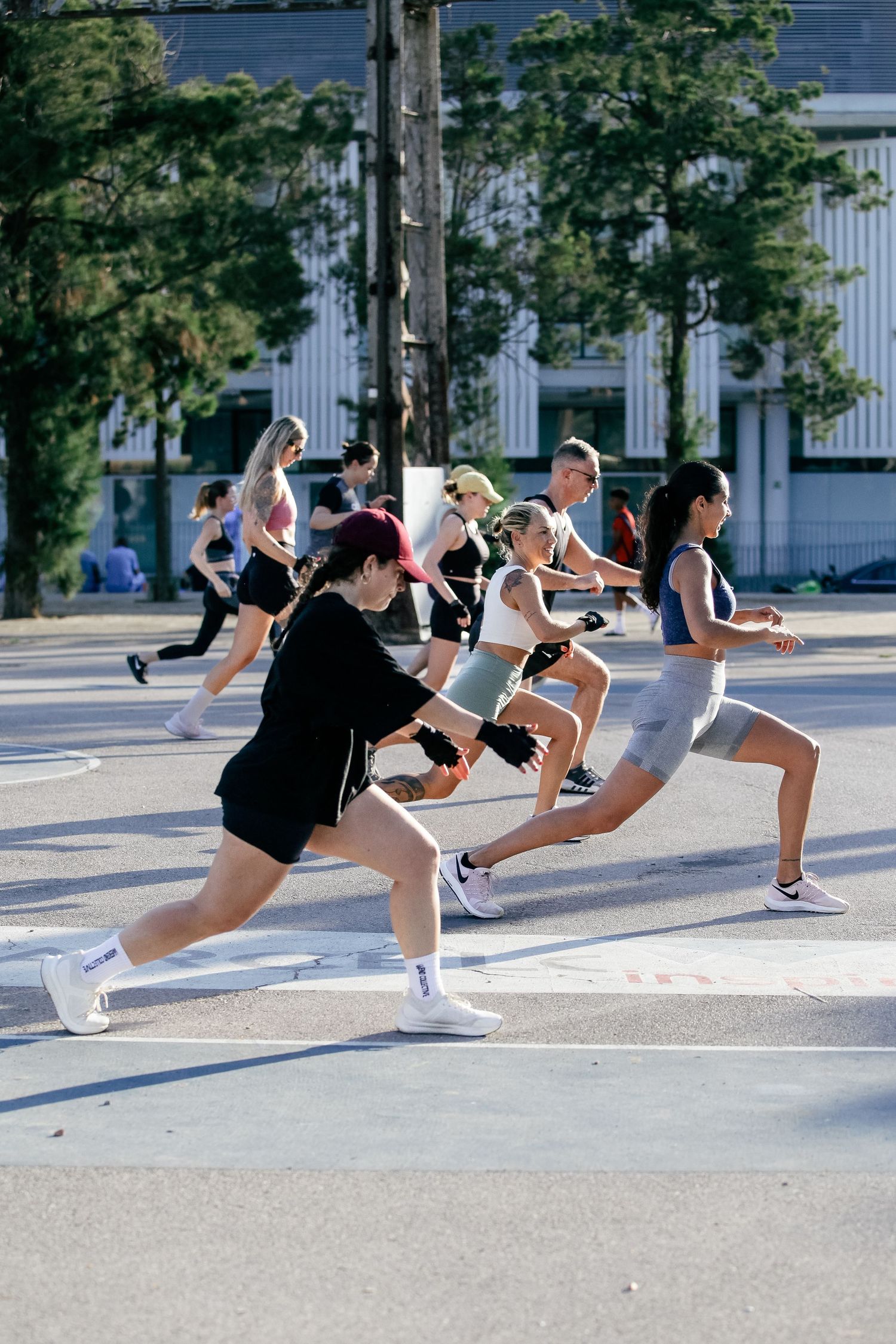 Group of dancers practicing synchronized kicks in an outdoor formation.
