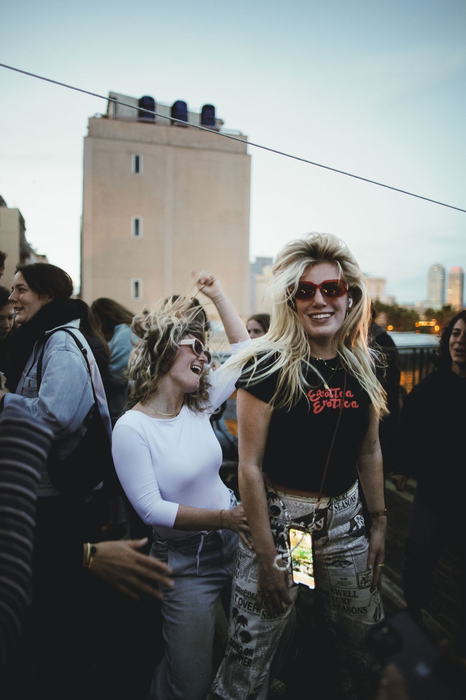 Group of friends dancing and celebrating outdoors during sunset.