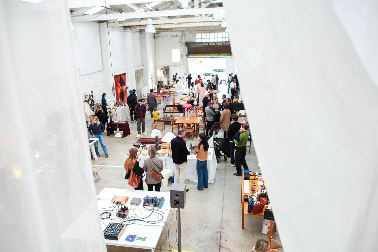 People browsing items displayed in a bright white gallery or showroom space.